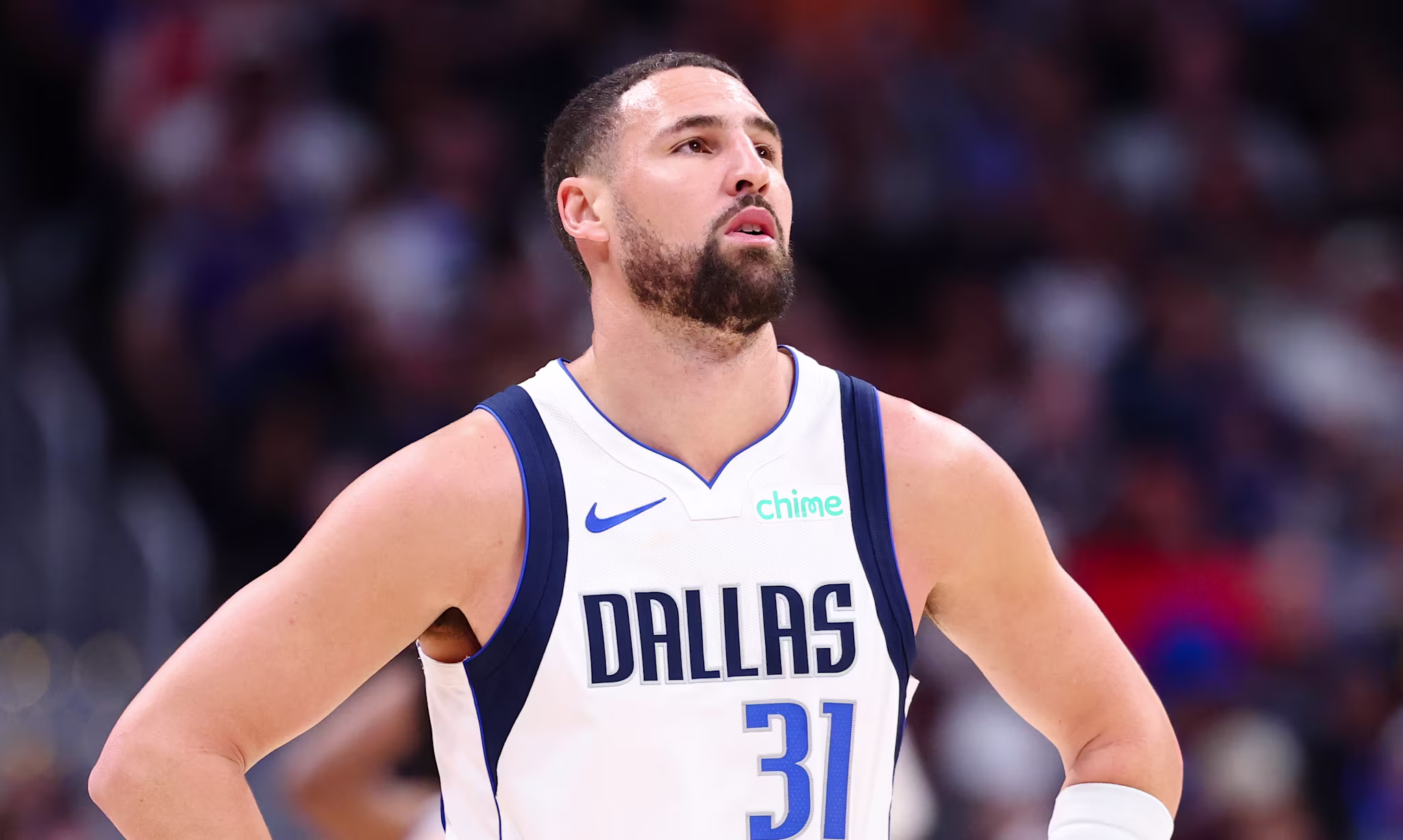 Klay Thompson in a Dallas jersey with the number 31, standing on the court during a game, looking focused.
