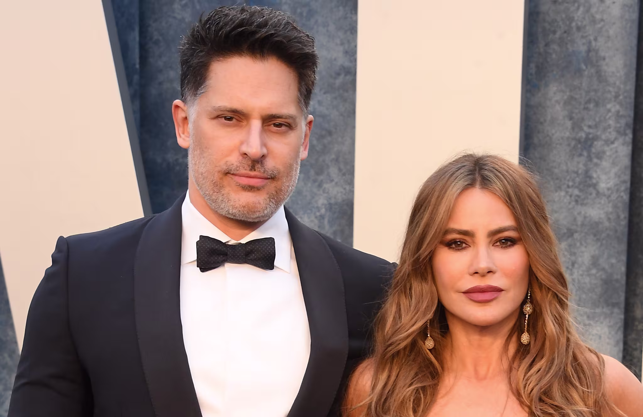 Joe Manganiello in a black tuxedo and Sofia Vergara in a gold embellished gown at a formal event.