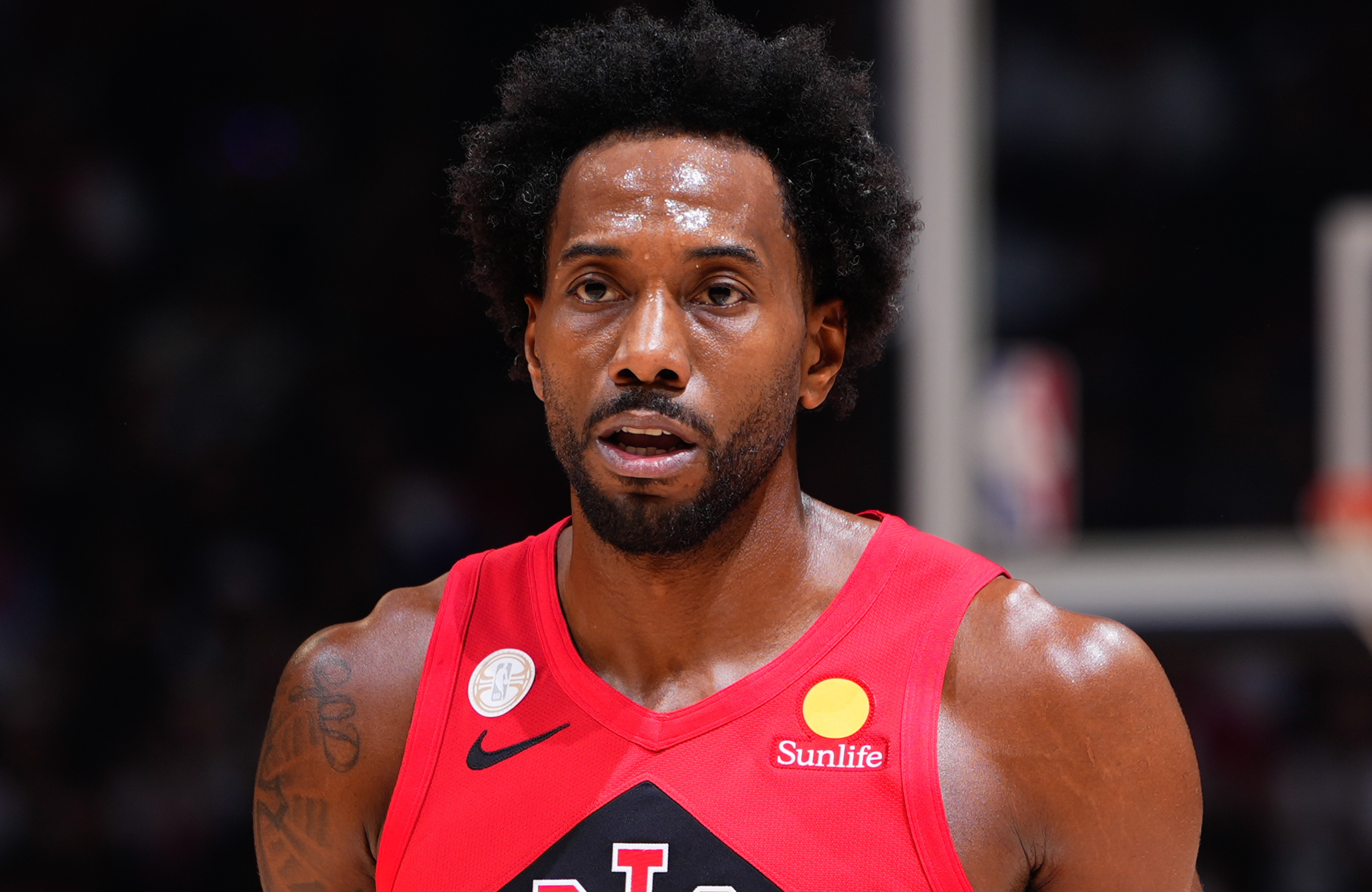 Kawhi Leonard in a red jersey with sponsor logos, on the court during a game.
