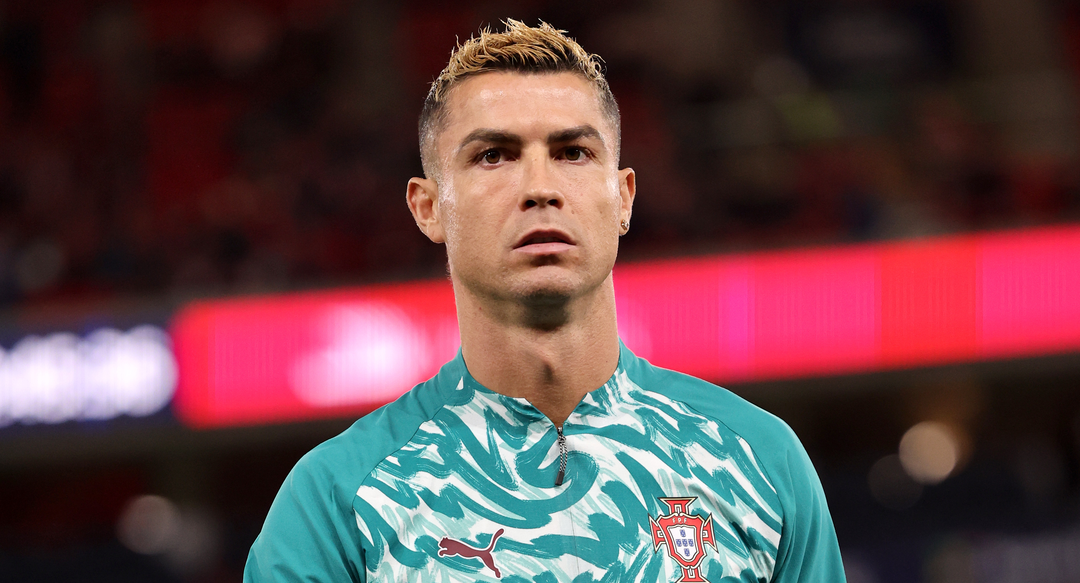 Cristiano Ronaldo in a Portugal training jersey with the number 7, on a football field.