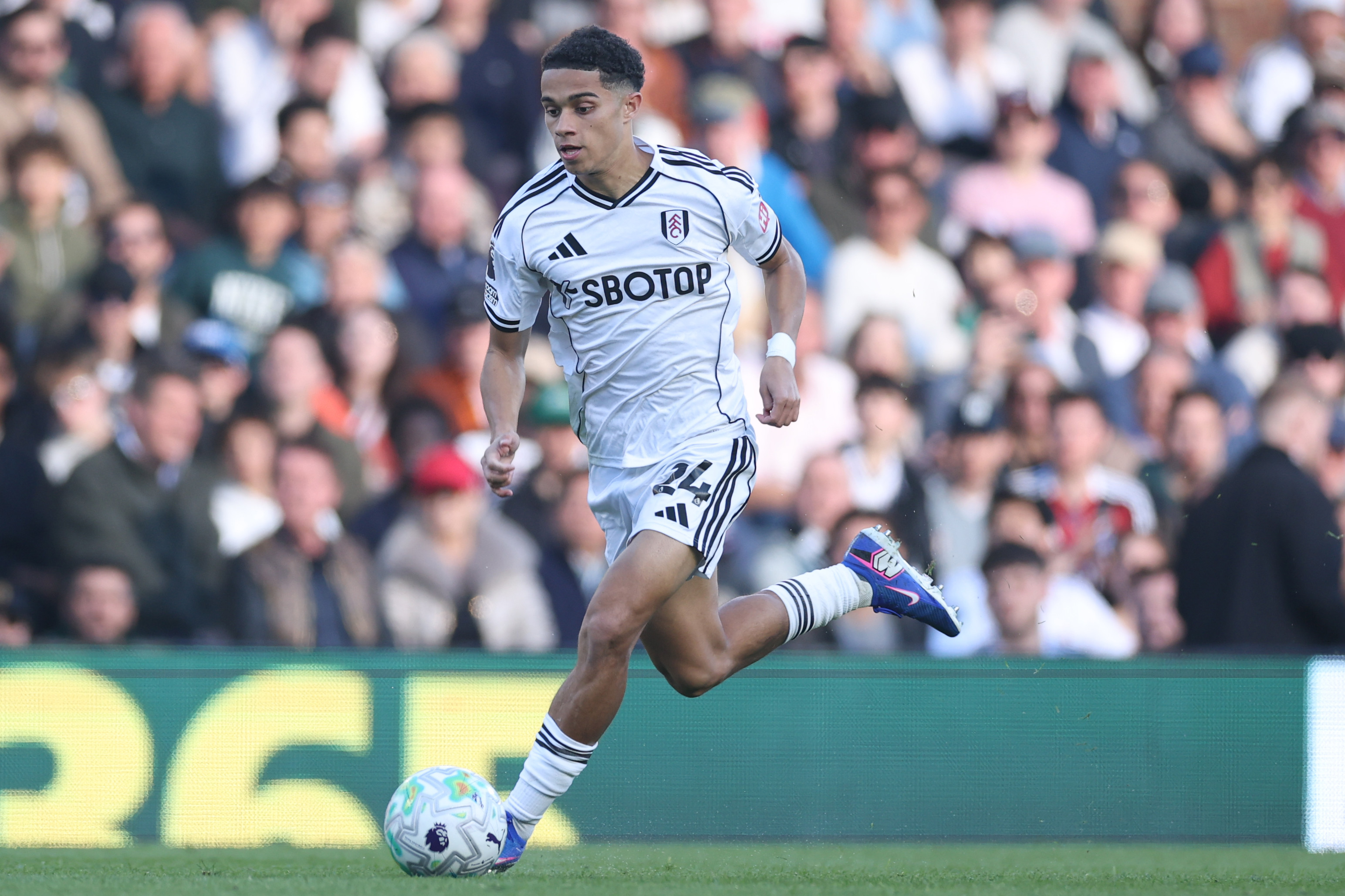 Josh King dribbles the ball up the pitch for Fulham. 