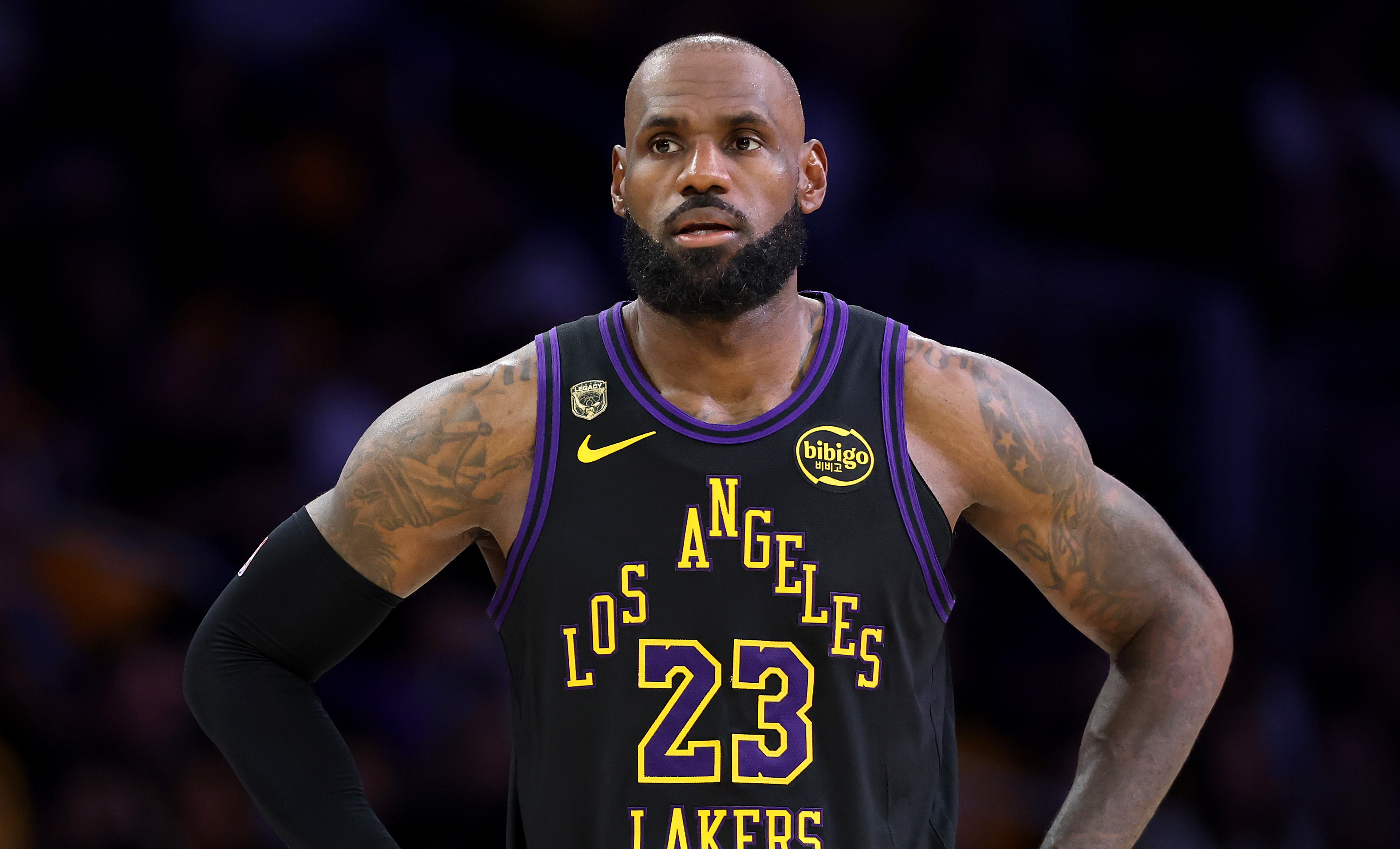 LeBron James in a Los Angeles Lakers jersey, standing with hands on hips during a basketball game.