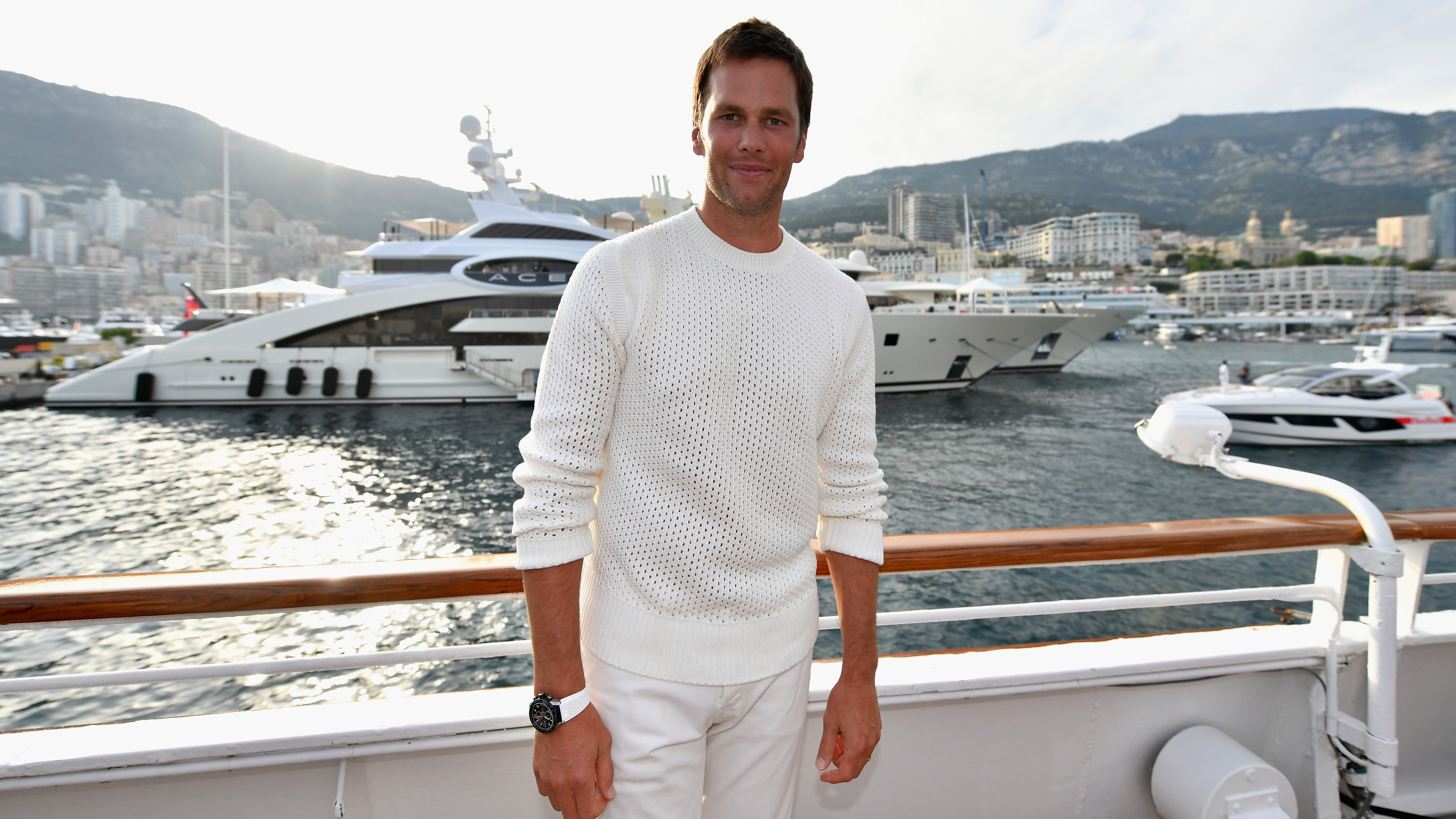 NFL star Tom Brady poses for a photo after throwing a ball to Daniel Ricciardo of Australia and Red Bull Racing on the TAG Heuer boat after qualifying for the Monaco Formula One Grand Prix at Circuit de Monaco on May 26, 2018 in Monte-Carlo, Monaco.