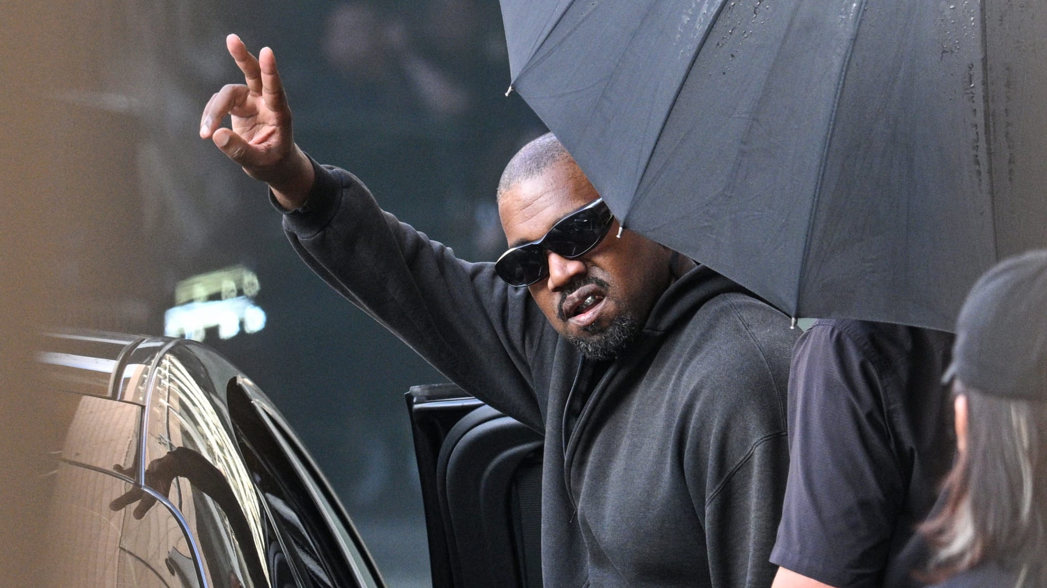 US rapper and producer Kanye West gestures upon arriving at Shanghai Pudong International Airport.