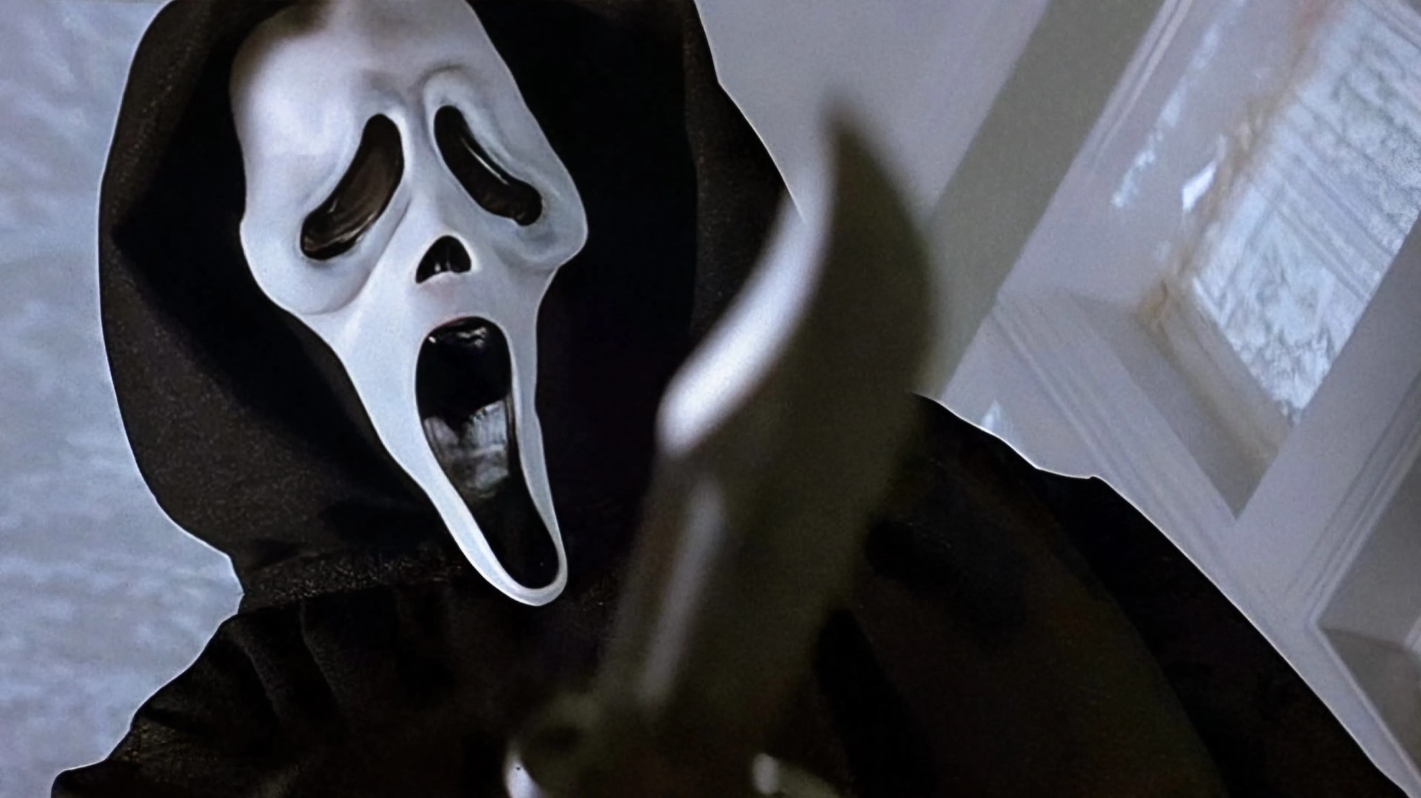 Ghostface from the "Scream" series, wearing a white mask and black robe, holding a knife in a threatening pose.