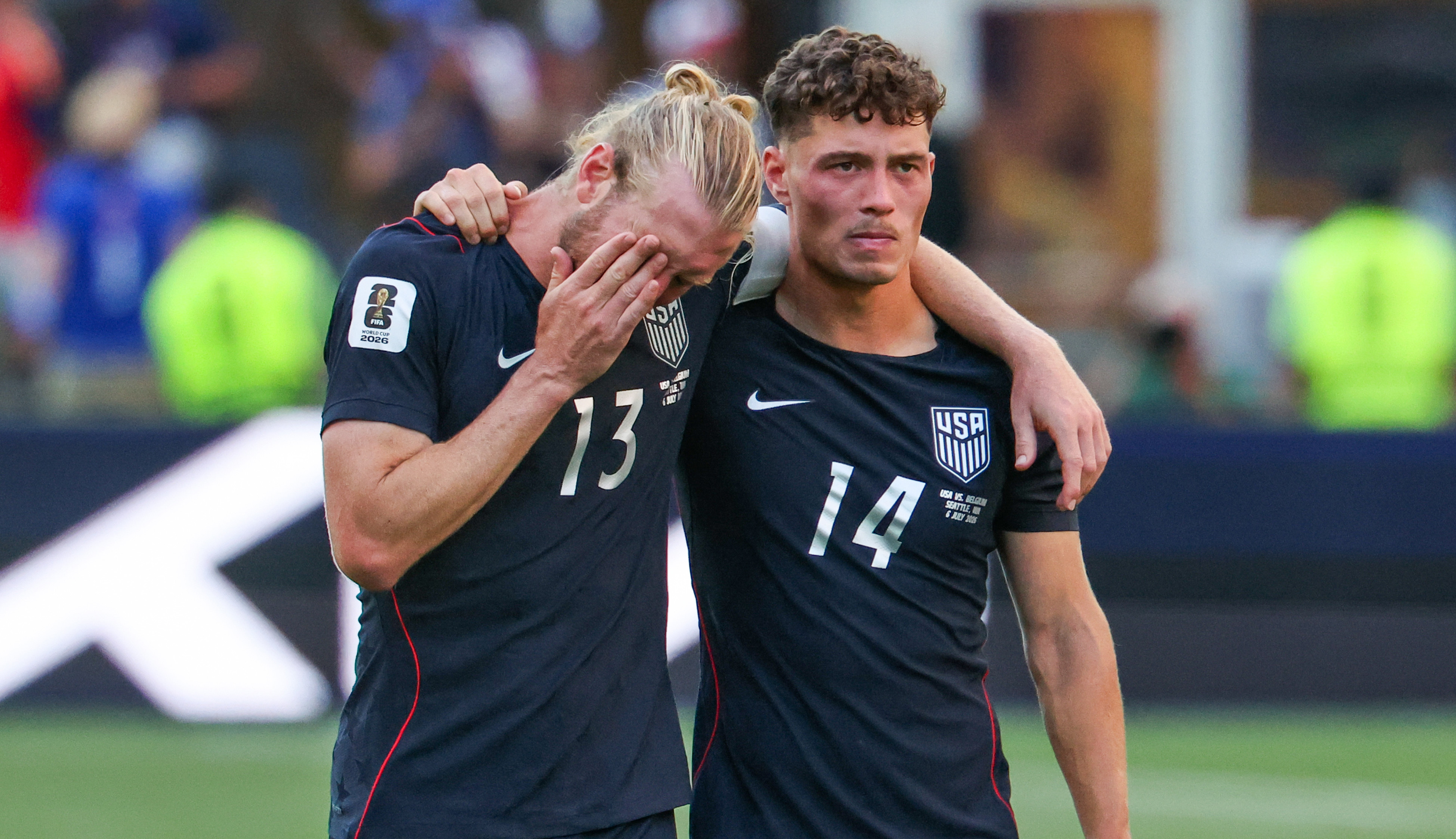 Sebastian Berhalter comforting Tim Ream who looks upset. They stand on a field with a blurred background.