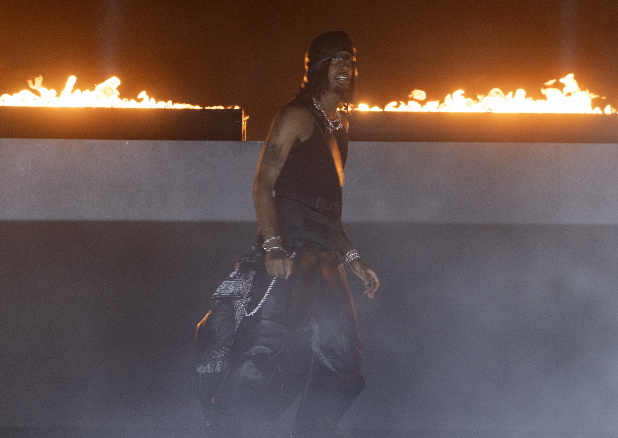 Playboi Carti wearing all black in front of fire