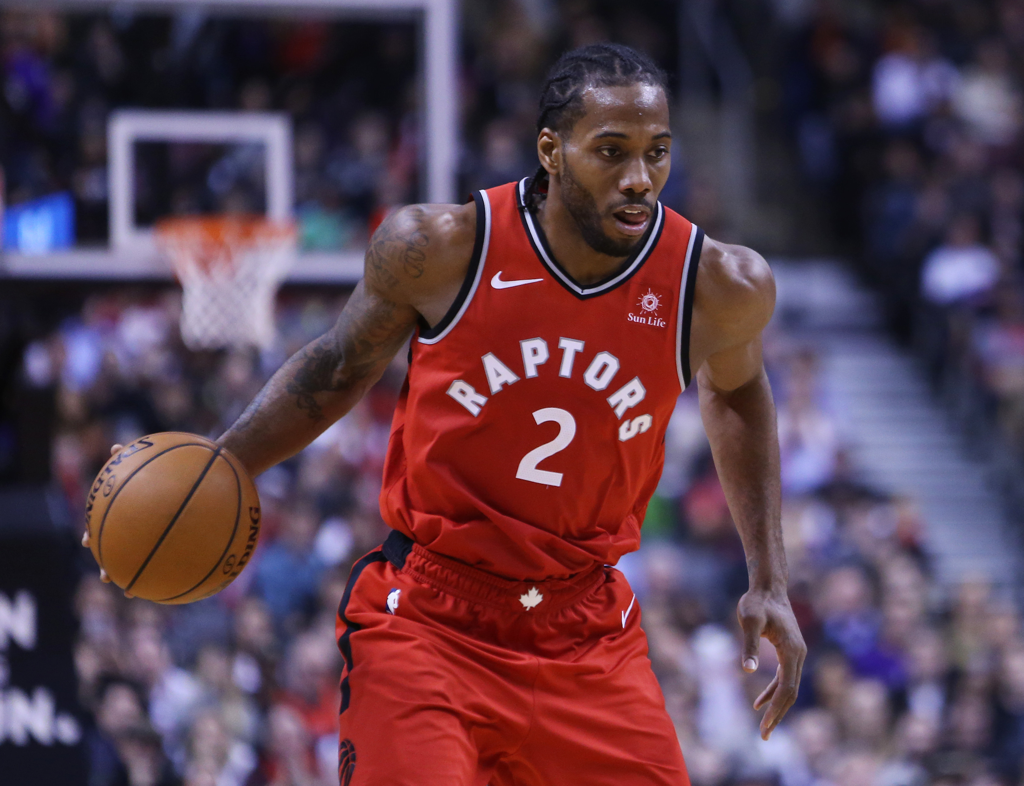 Kawhi Leonard  dribbles the ball during a Toronto Raptors game in 2018. 