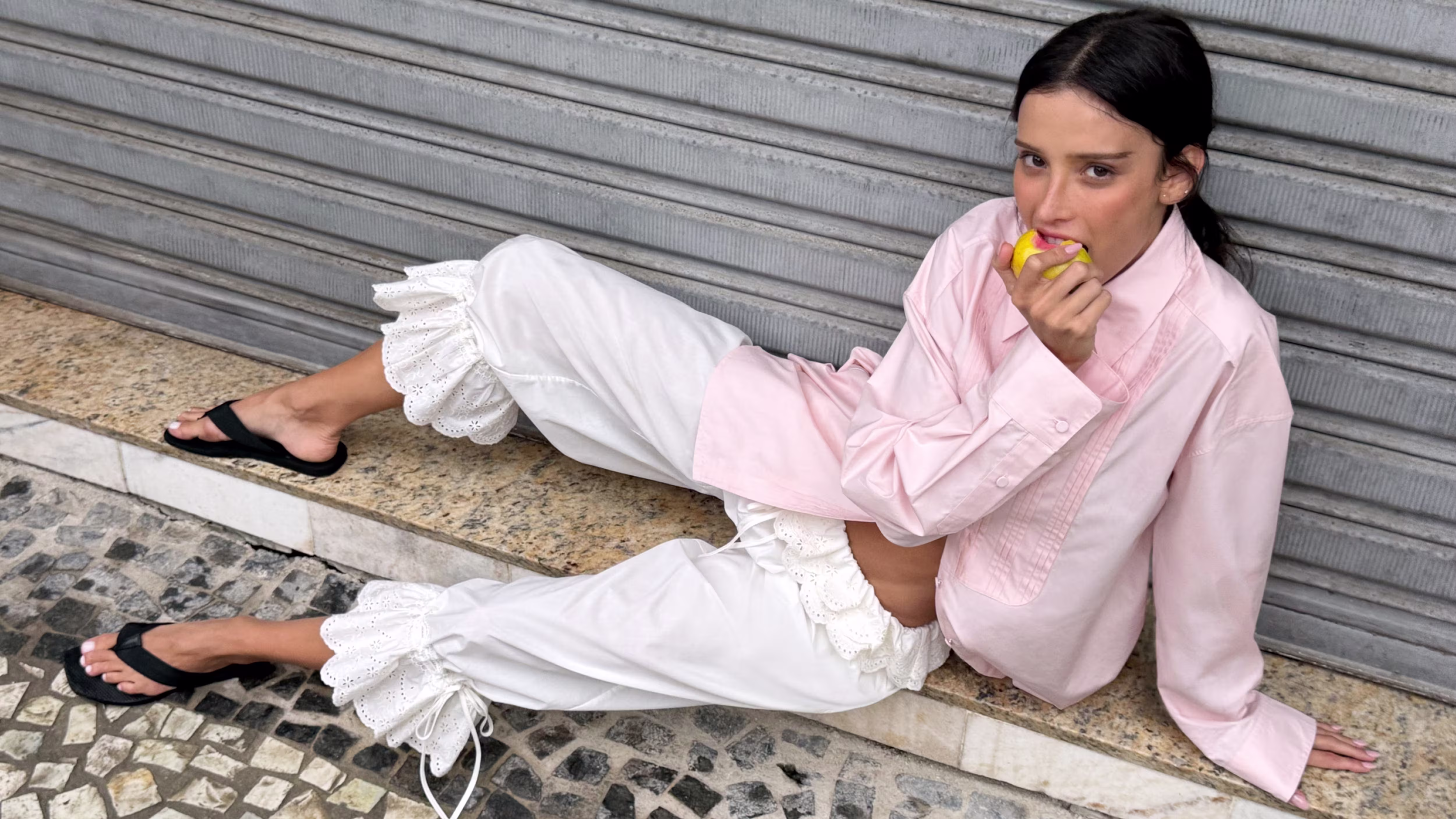 A woman lying down and eating an apple.