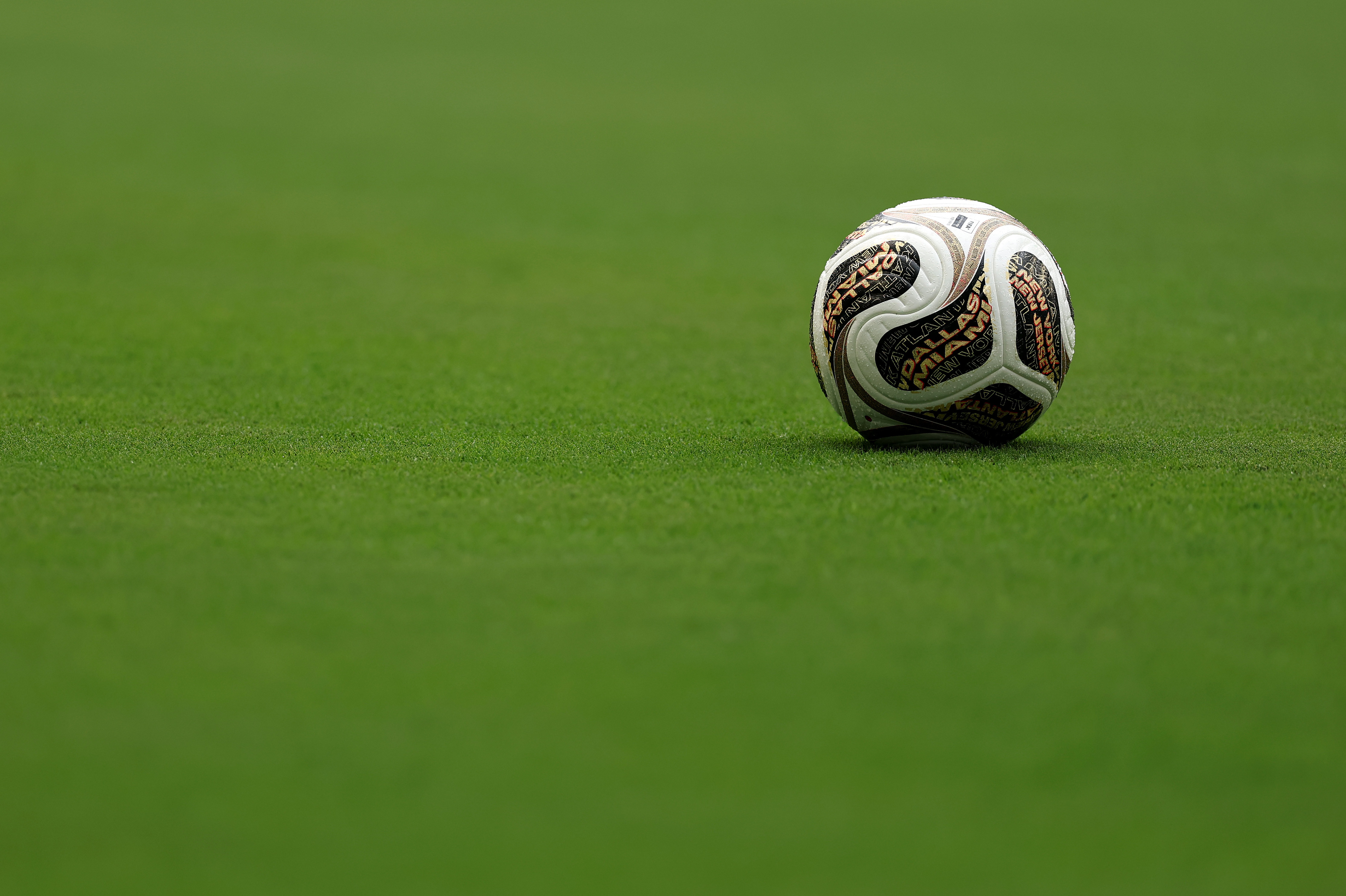 A soccer ball on a lush green field, centered in the image.