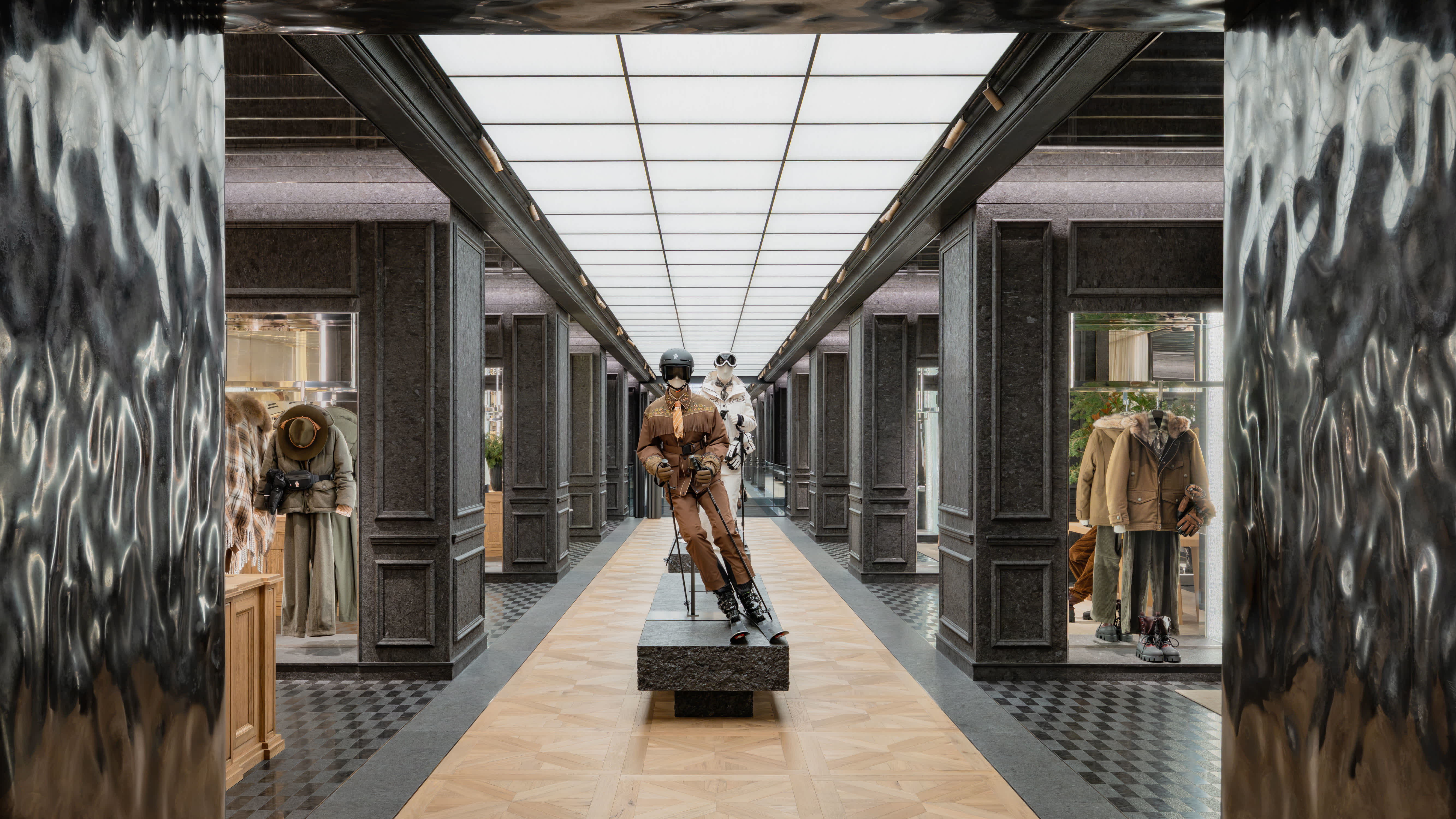 A luxurious Moncler store interior with mannequins displaying stylish outfits. The space features a modern design with elegant lighting.