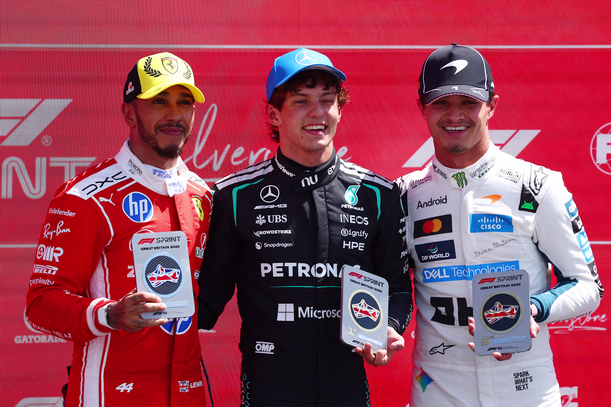 Lewsi Hamilton, Kimi Antonelli, and Lando Norris pose prior to the F1 Grand Prix of Britain in July 2026. 