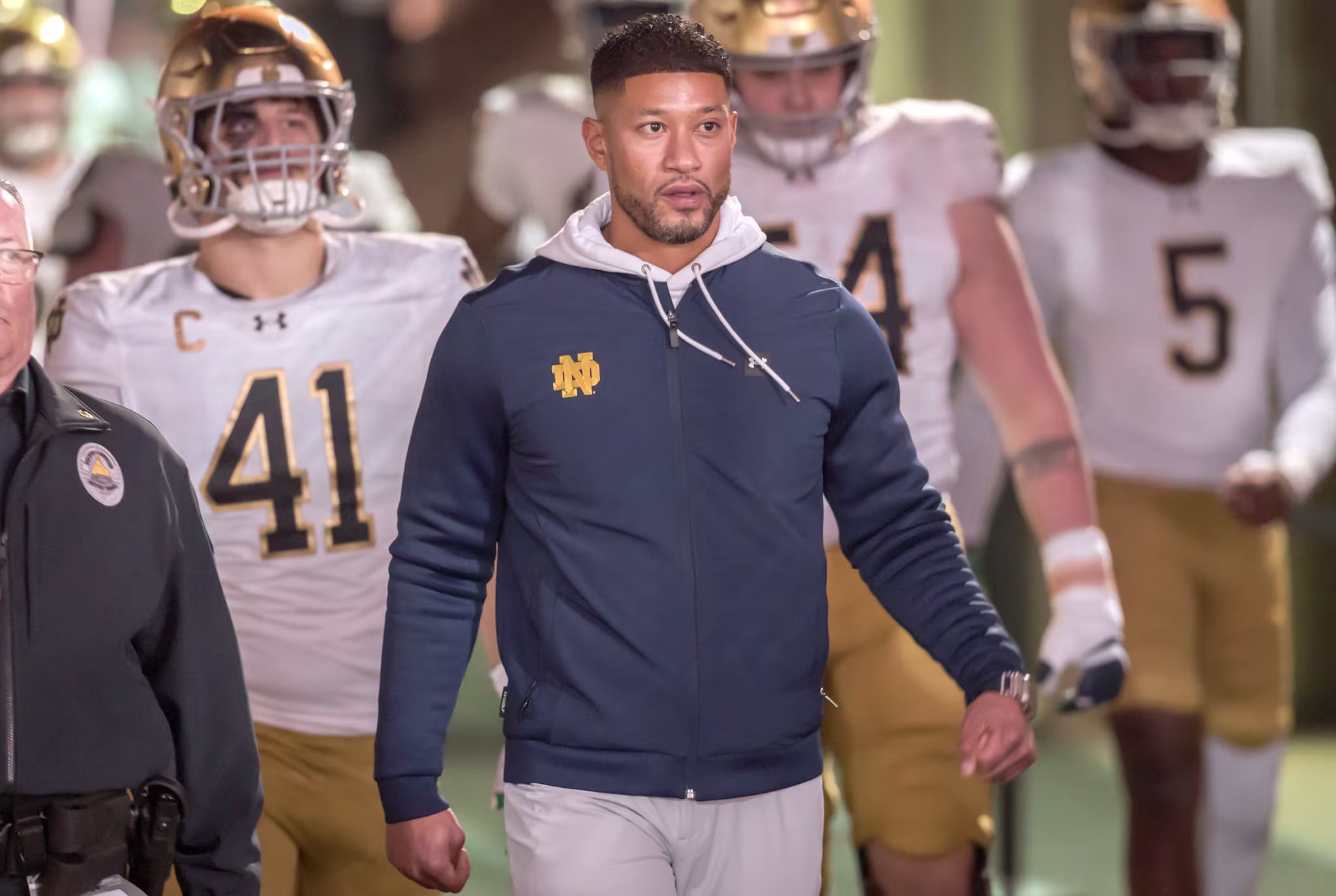 Notre Dame head coach Marcus Freeman leads the Fighting Irish onto the field before a game in November 2025. 