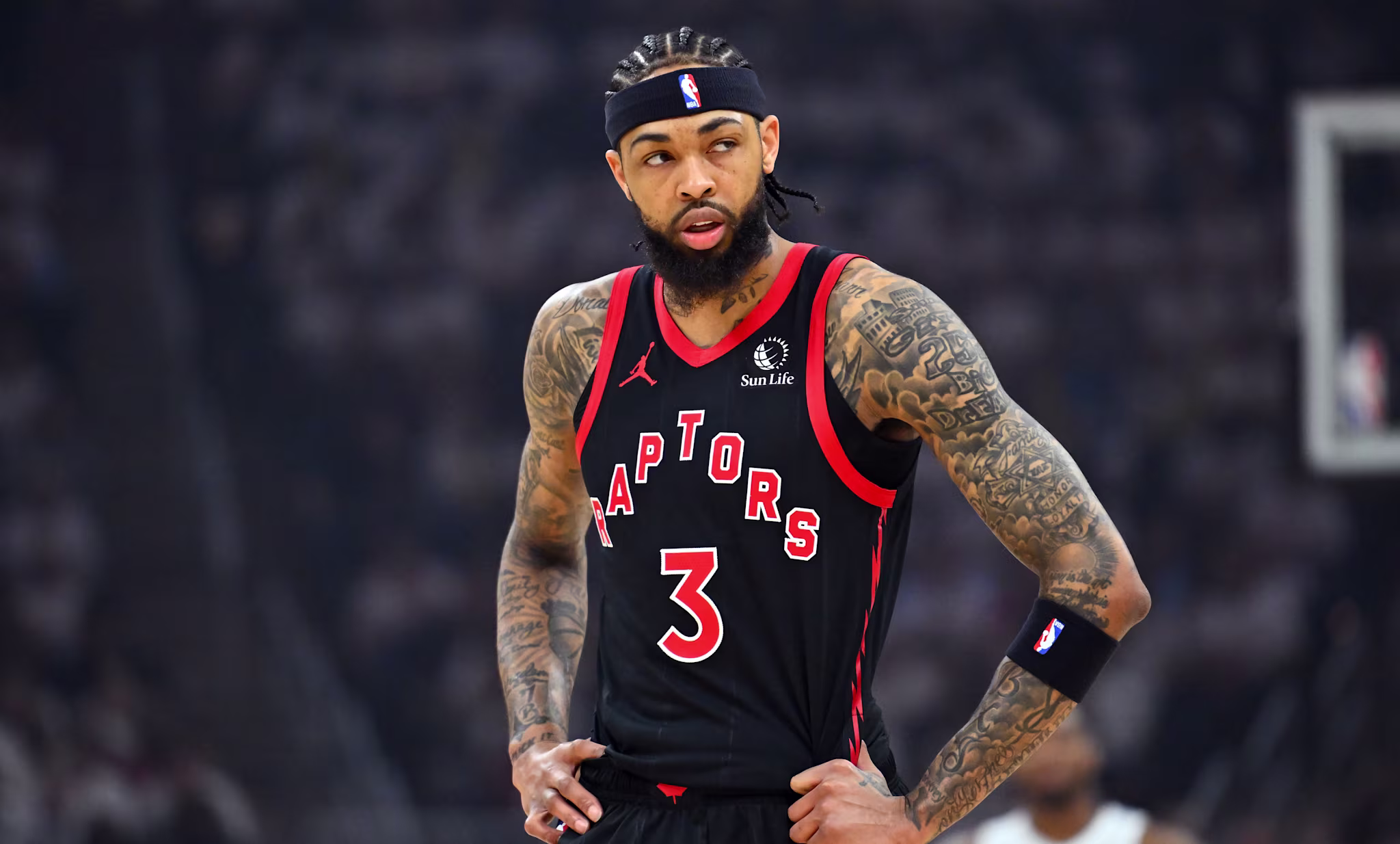 Brandon Ingram in a Toronto Raptors uniform, number 3, stands on the court with hands on hips, wearing a headband and arm sleeve.