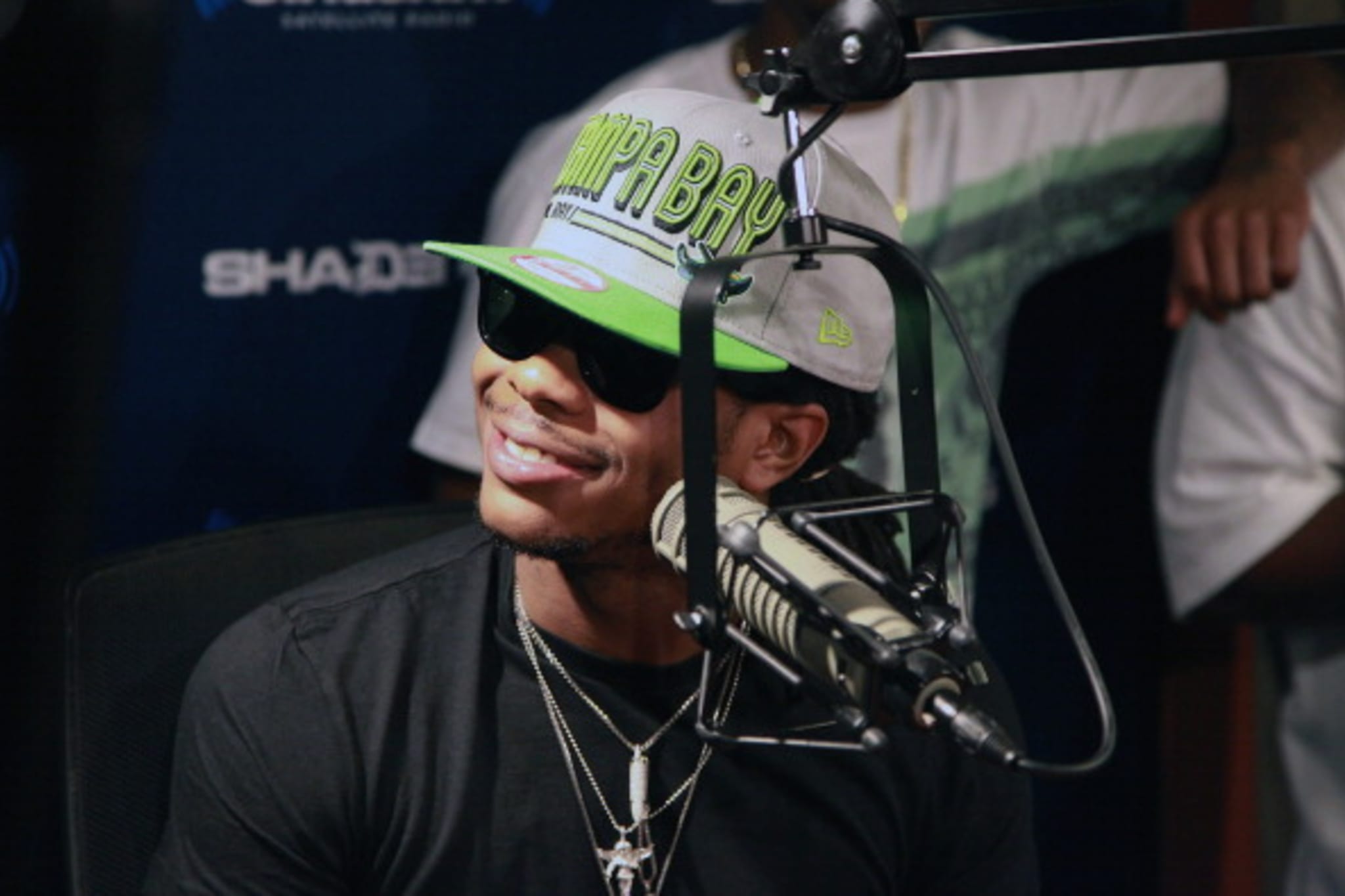 Cash Out speaking into a microphone in a radio studio.