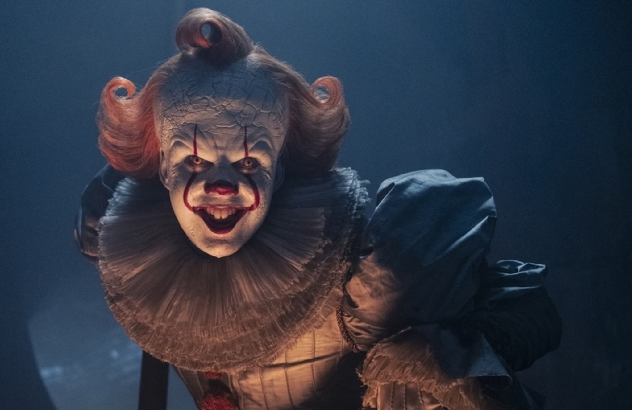 Pennywise the Clown from "It," with a sinister grin, in a dimly lit setting.