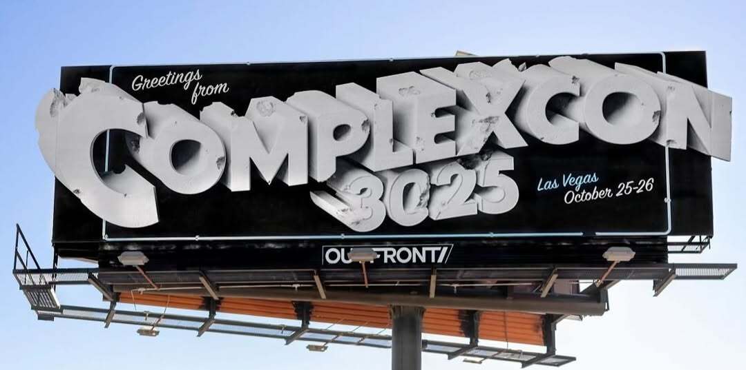 A black vintage Porsche with luggage on top is parked under a billboard for "ComplexCon 3025" in Las Vegas, October 25-26.