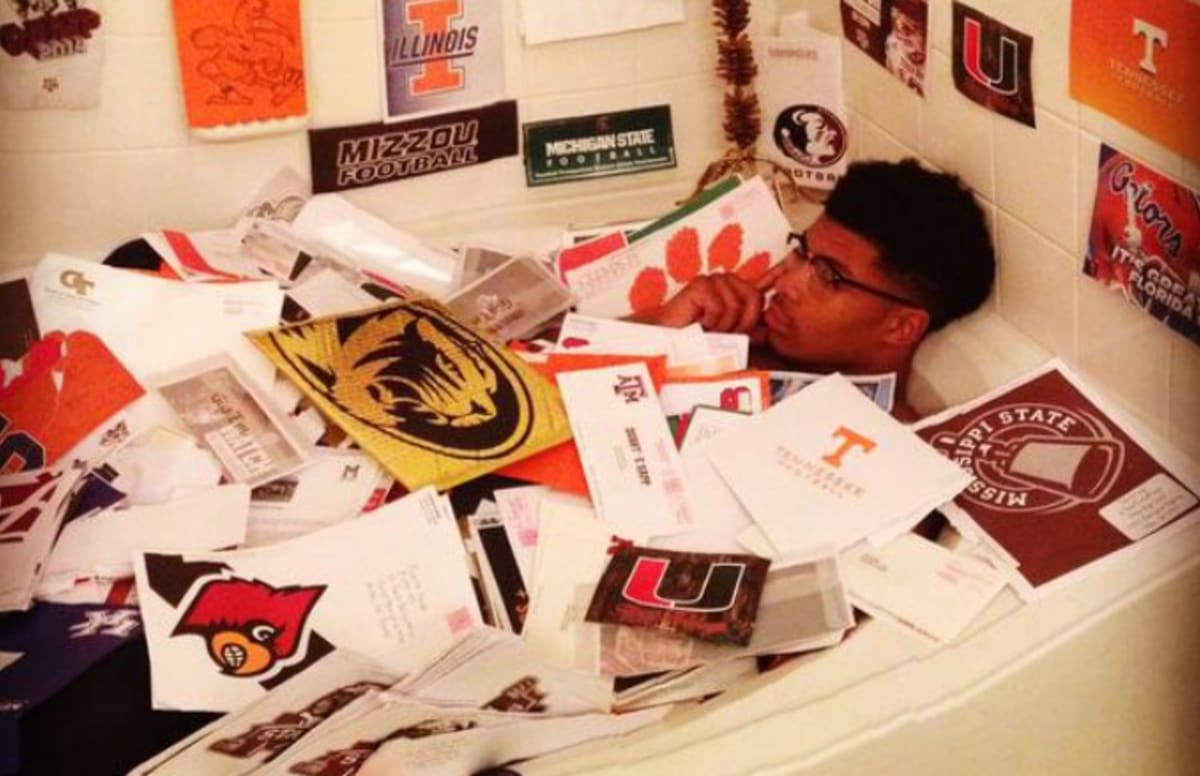 College Football Recruit Covers Himself With Recruiting Letters in