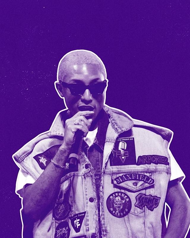 Pharrell with short hair and sunglasses, wearing a patch-covered denim vest, holding a microphone against a purple background.
