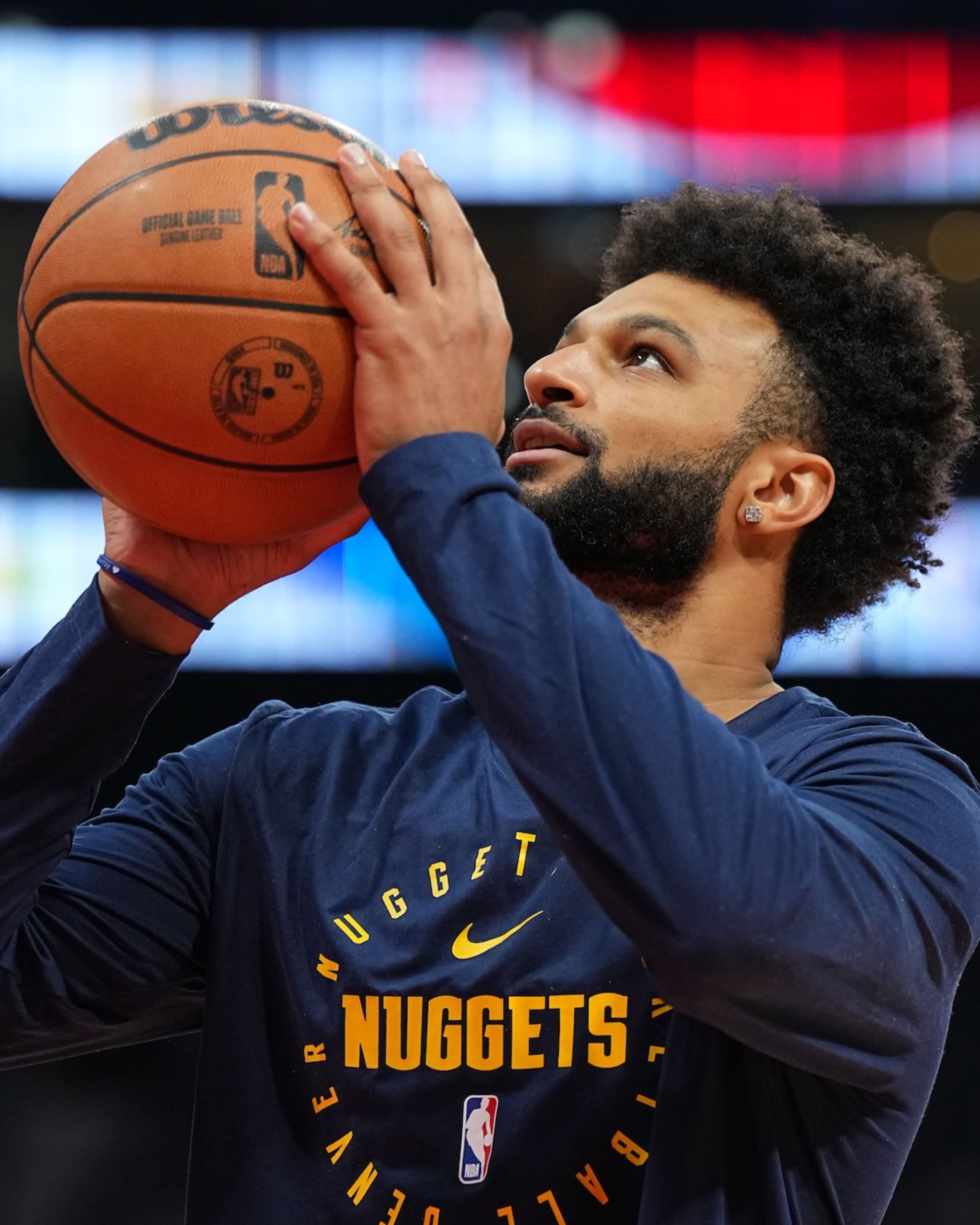 Jamal Murray from the Denver Nuggets is preparing to shoot the ball, wearing a team shirt during warm-up.
