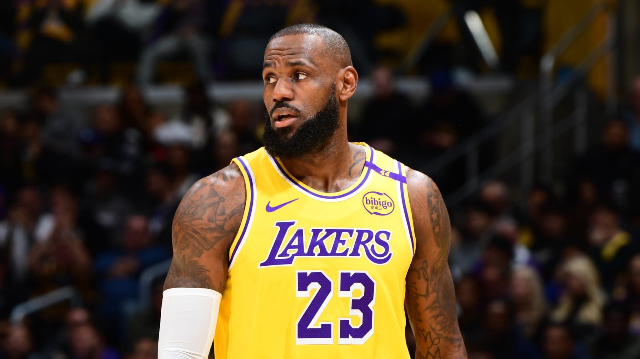 LeBron James in a Lakers jersey on a basketball court, looking to the side during a game.