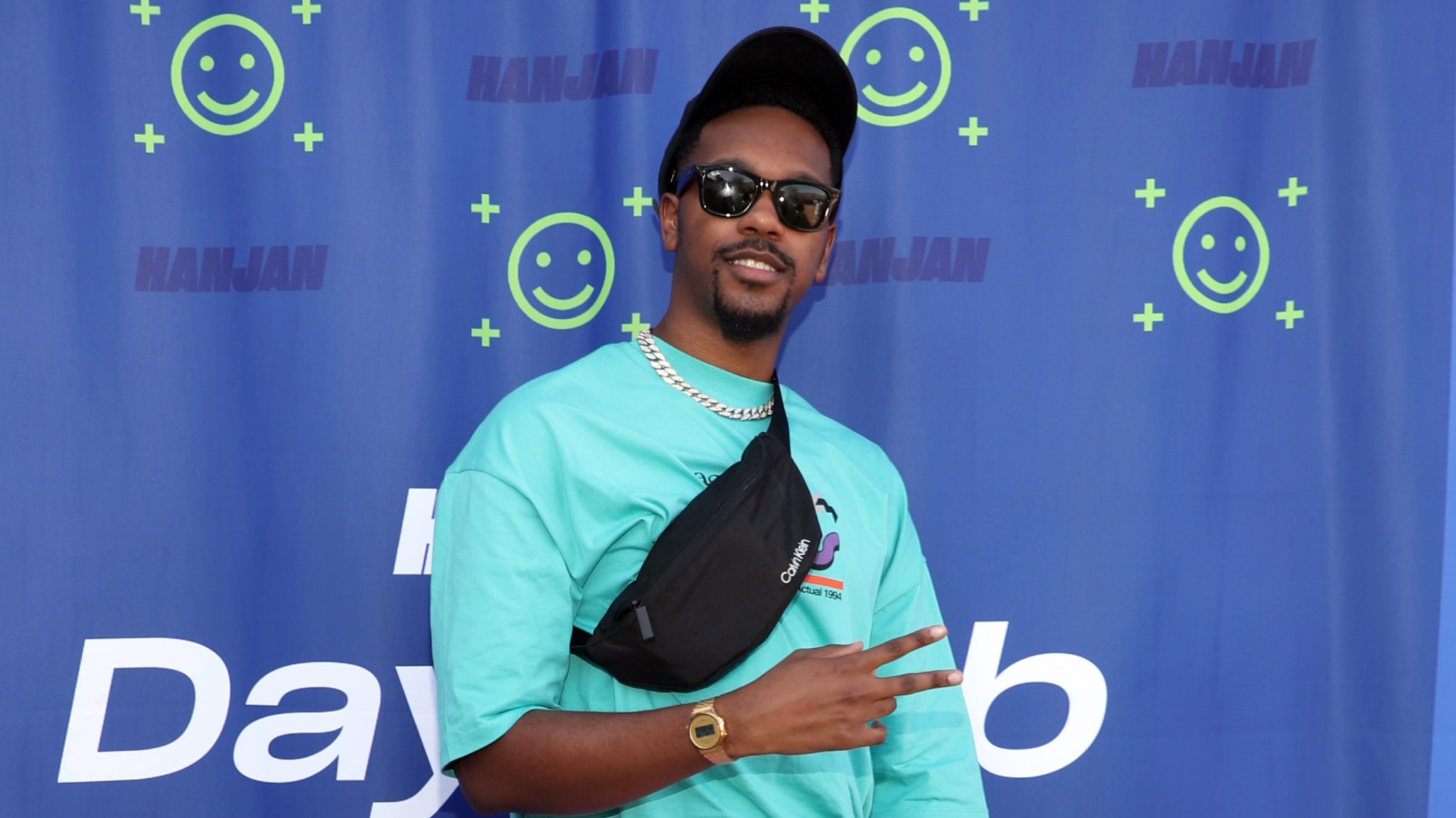 Reggie Couz poses in front of a blue background at Palm Desert, California's HANJAN Oasis in April 2022.