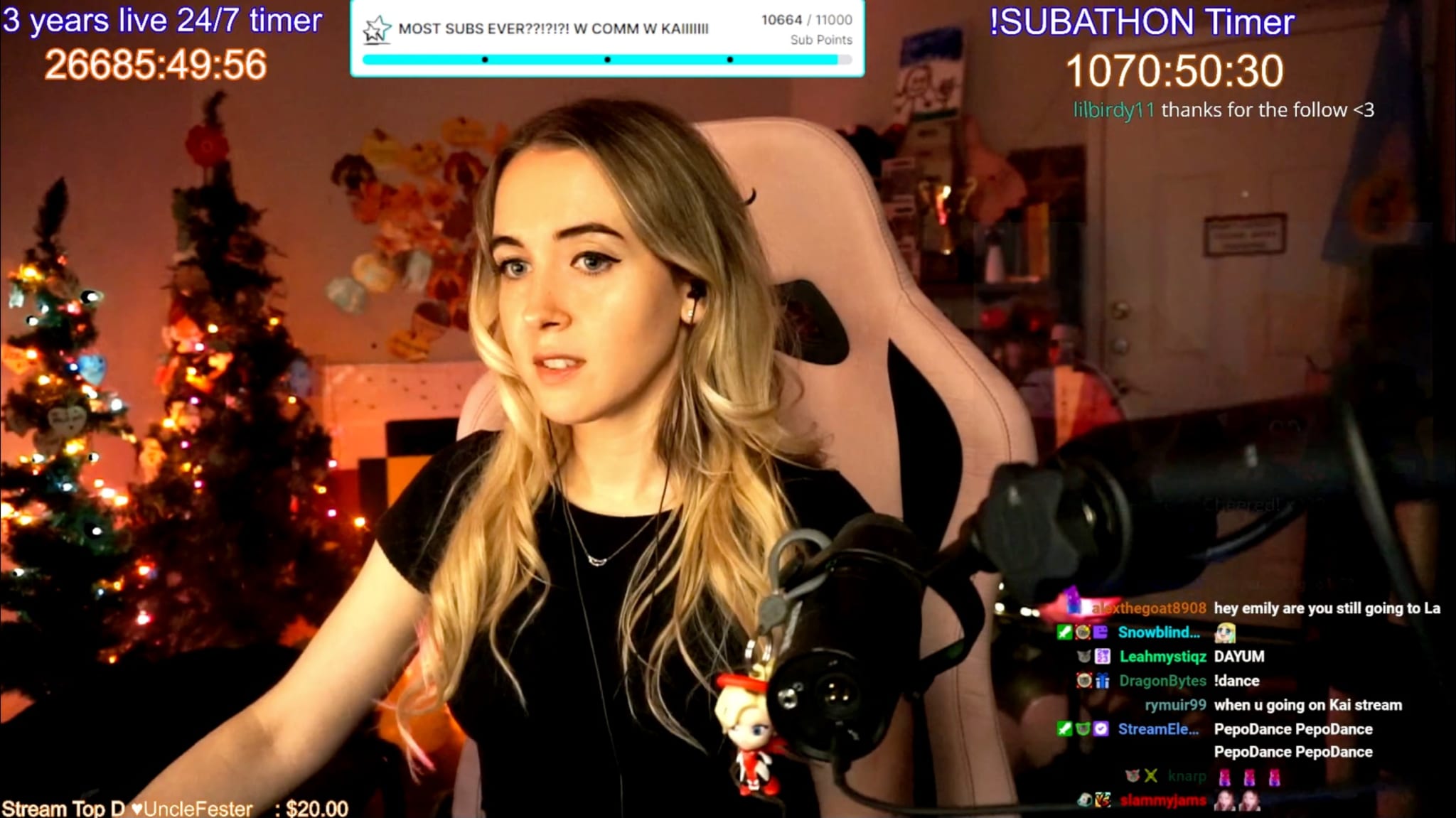 Emilycc sits in her room while livestreaming on Twitch, with a chatbox on the lower right and other text surrounding her.