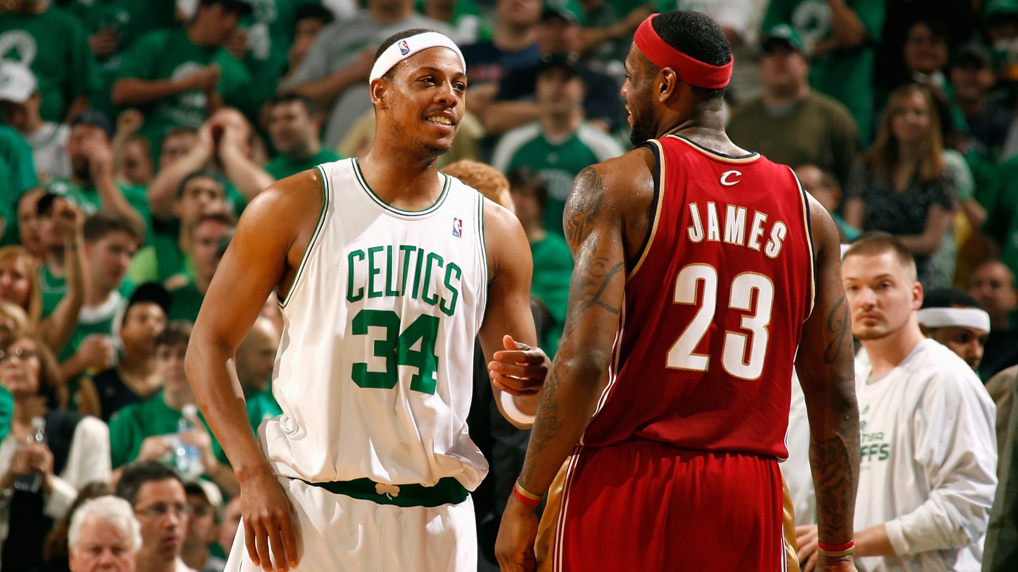 Paul Pierce and LeBron James on a basketball court, wearing Celtics and Cavaliers jerseys, respectively, during a game.