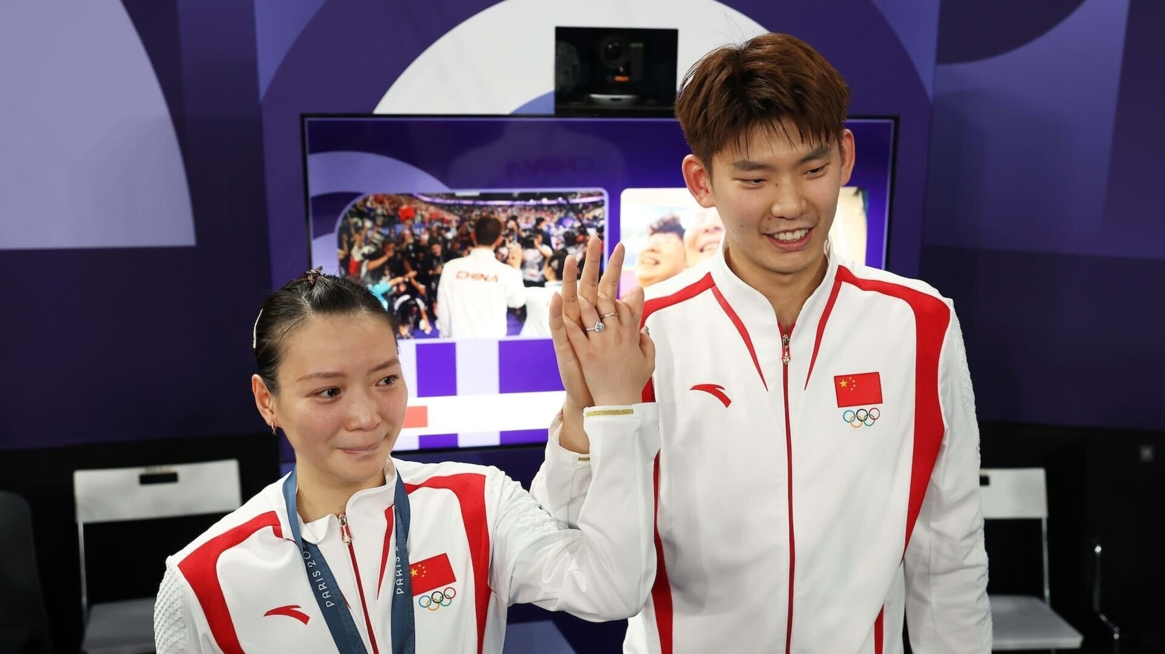 Chinese badminton players pose after proposal at award ceremony.