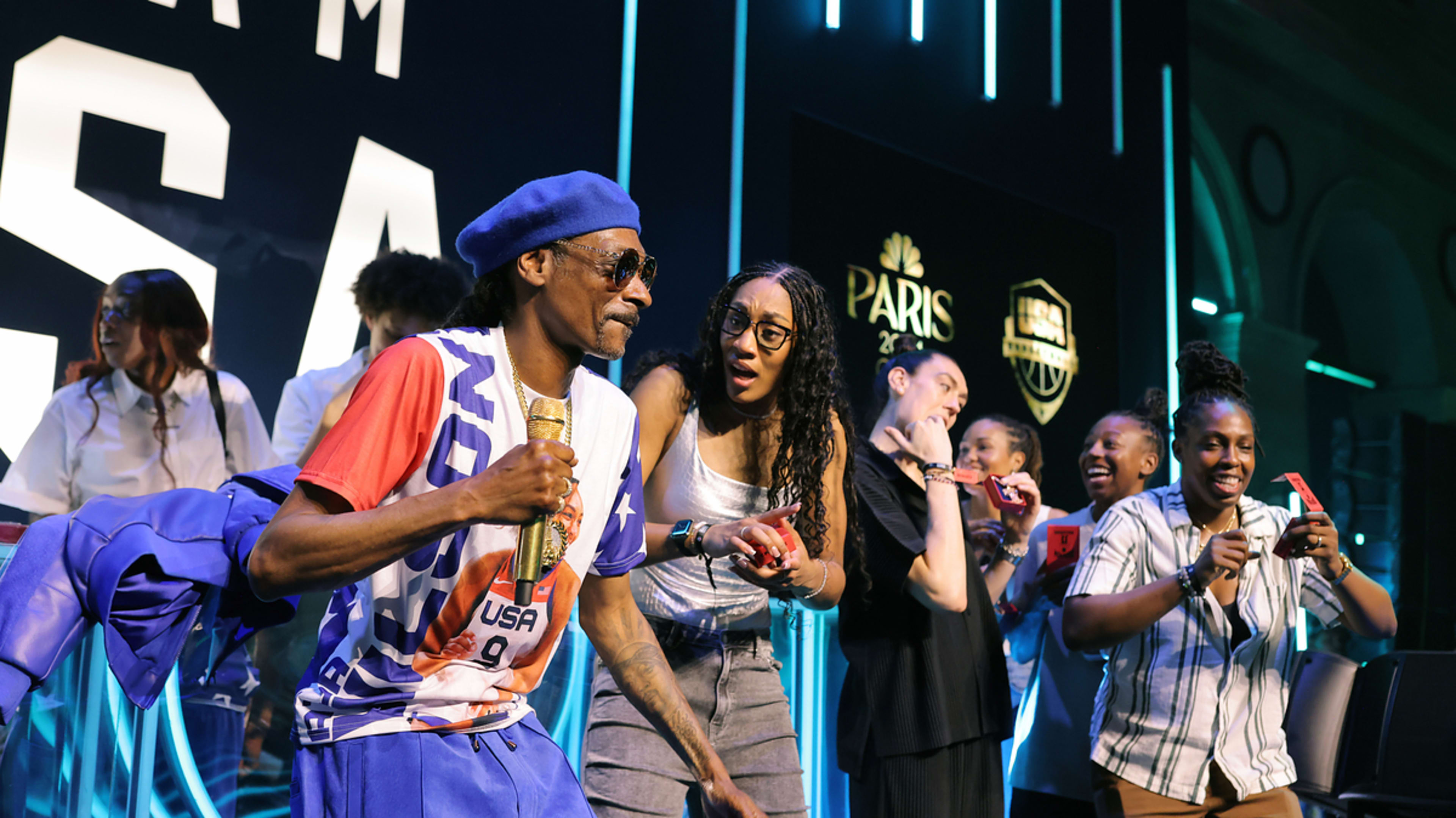 Snoop Dogg performs on stage alongside Sue Bird, Diana Taurasi, and other athletes at a Team USA event