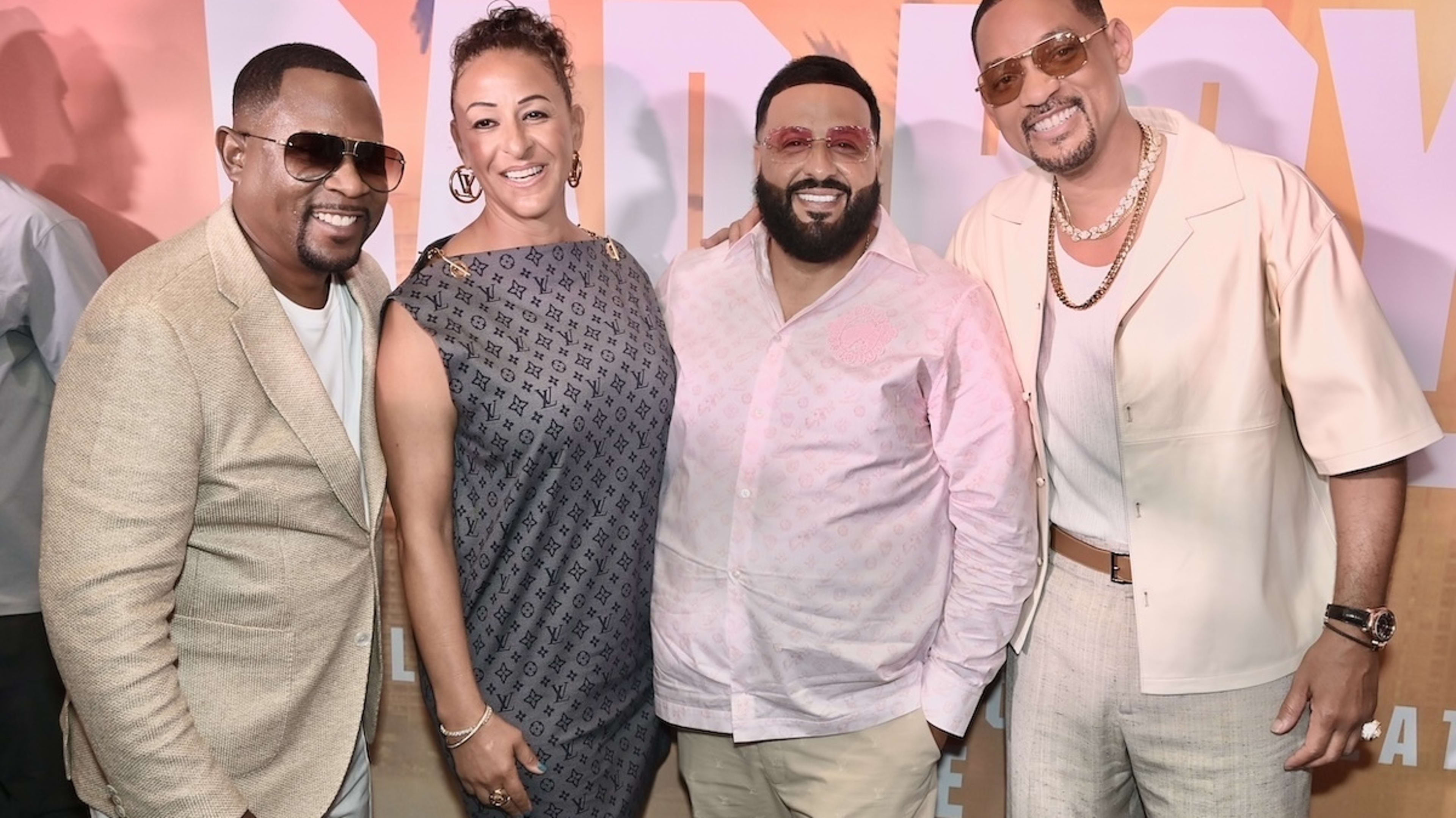 Martin Lawrence, guest, DJ Khaled, and Will Smith pose together at a red carpet event. Martin and Will wear stylish suits, while DJ Khaled wears a casual outfit