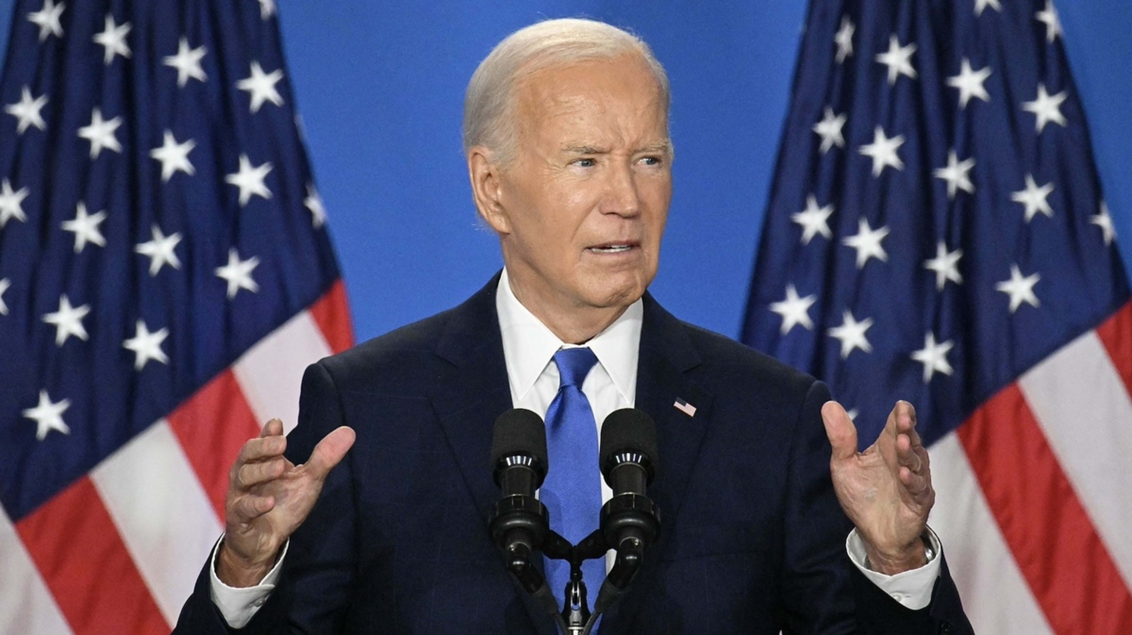 President Joe Biden speaks at a podium with two U.S. flags in the background