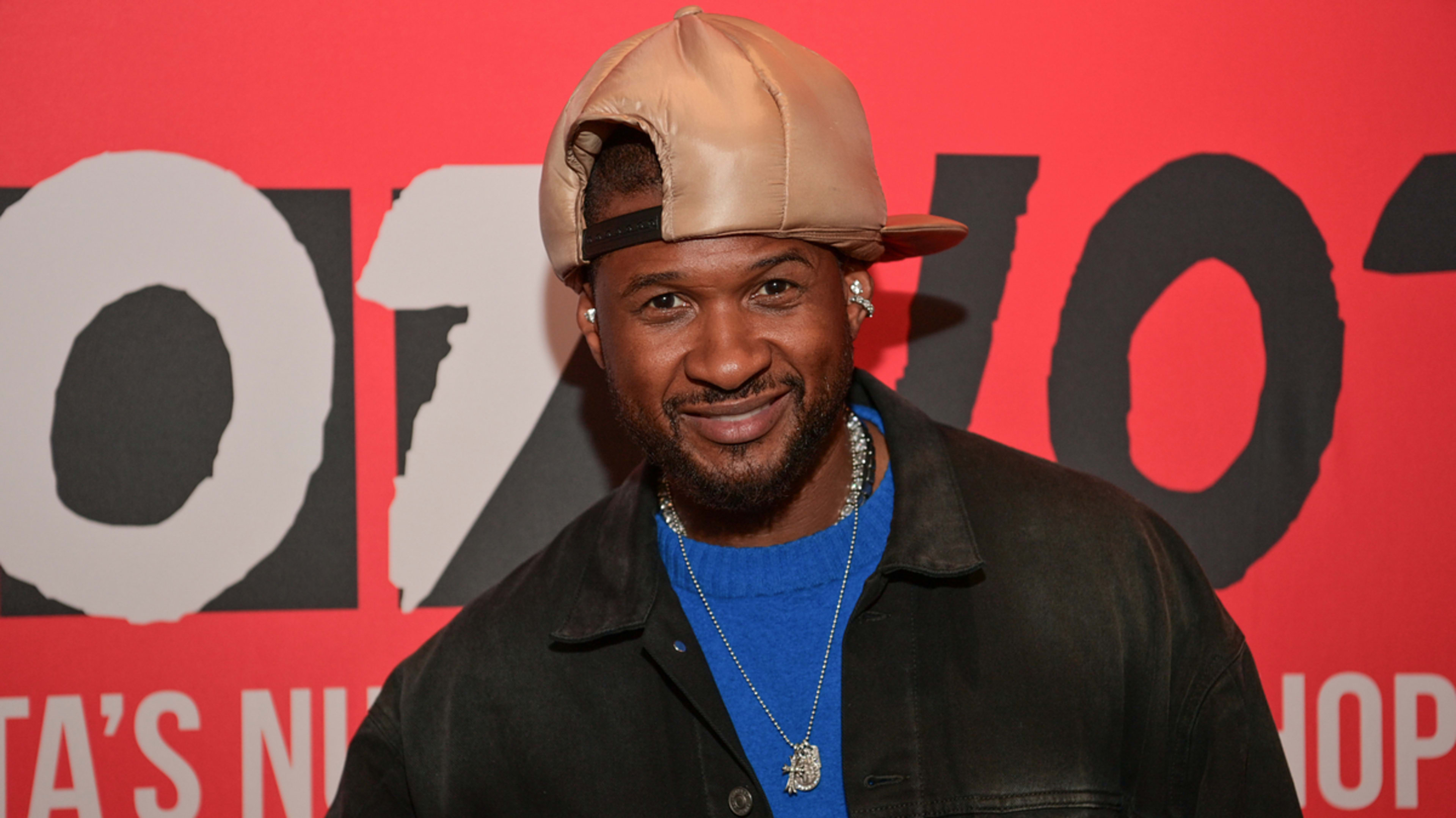 Man in leather jacket and baseball cap posing at Hot 97's event.

(Note: Specific names are not provided due to the guidelines stated, even though this individual may be recognizable.)