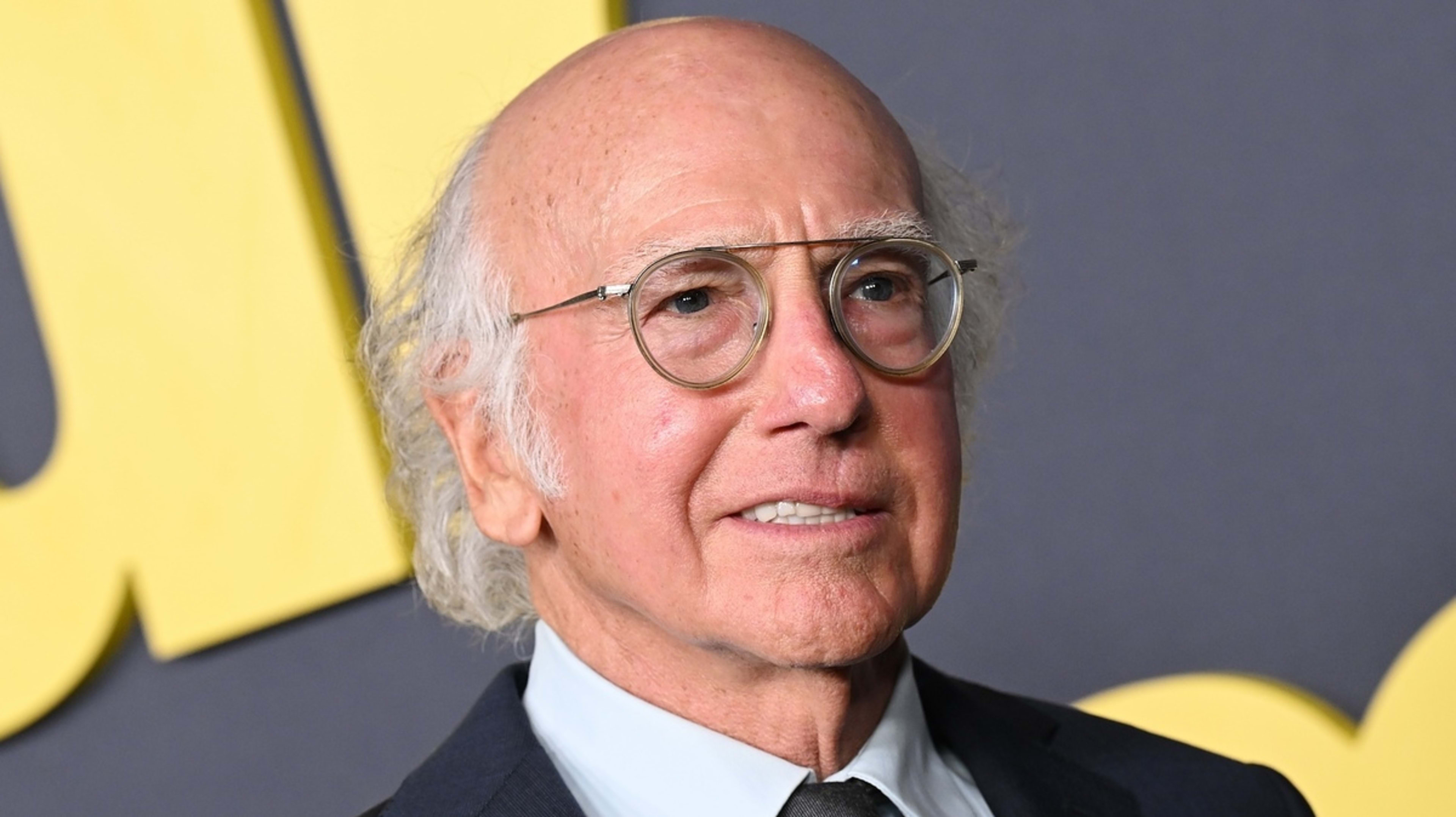 Larry David in a black suit and tie at an event