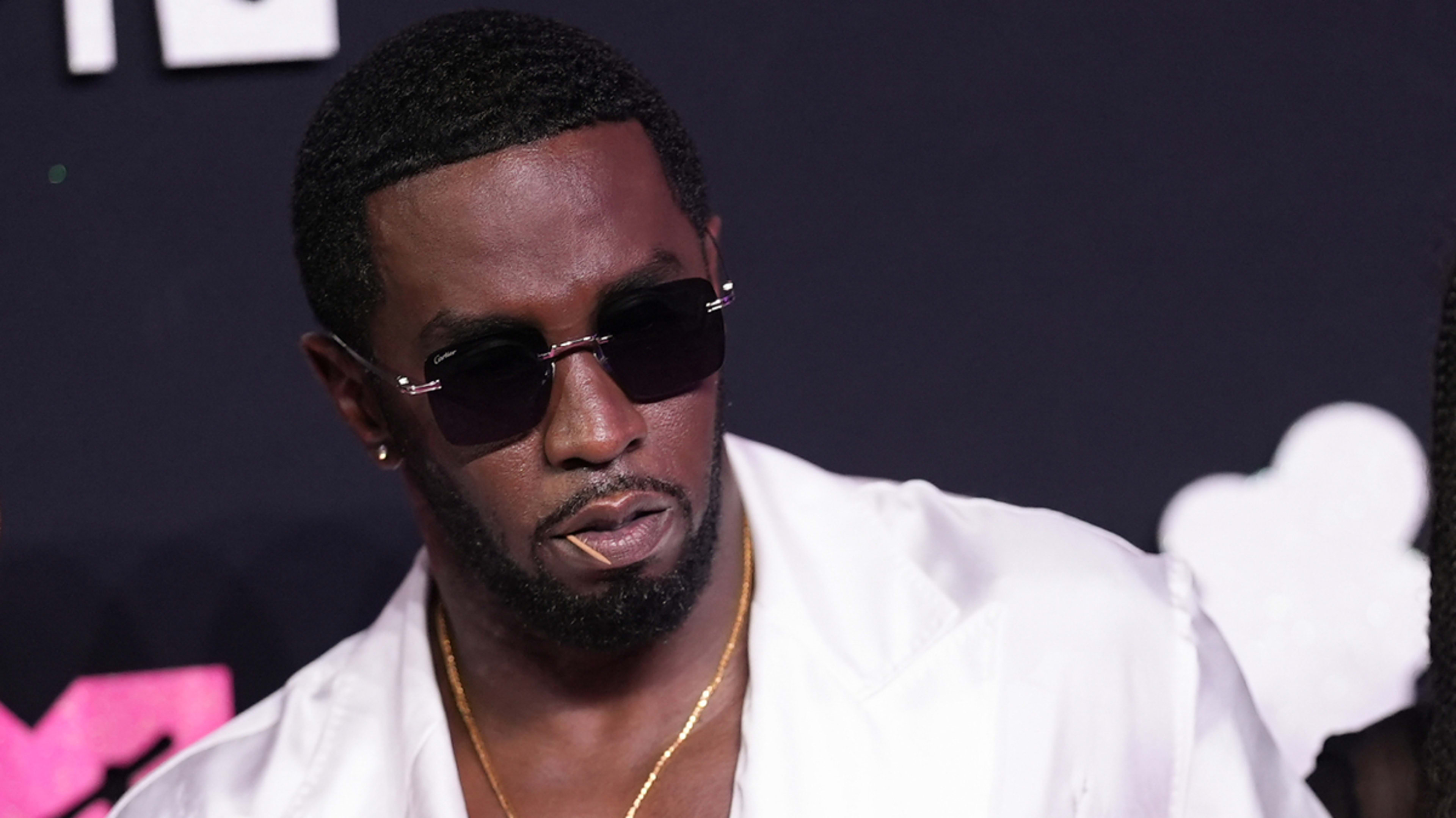 Sean "Diddy" Combs in a white outfit with sunglasses at a music event