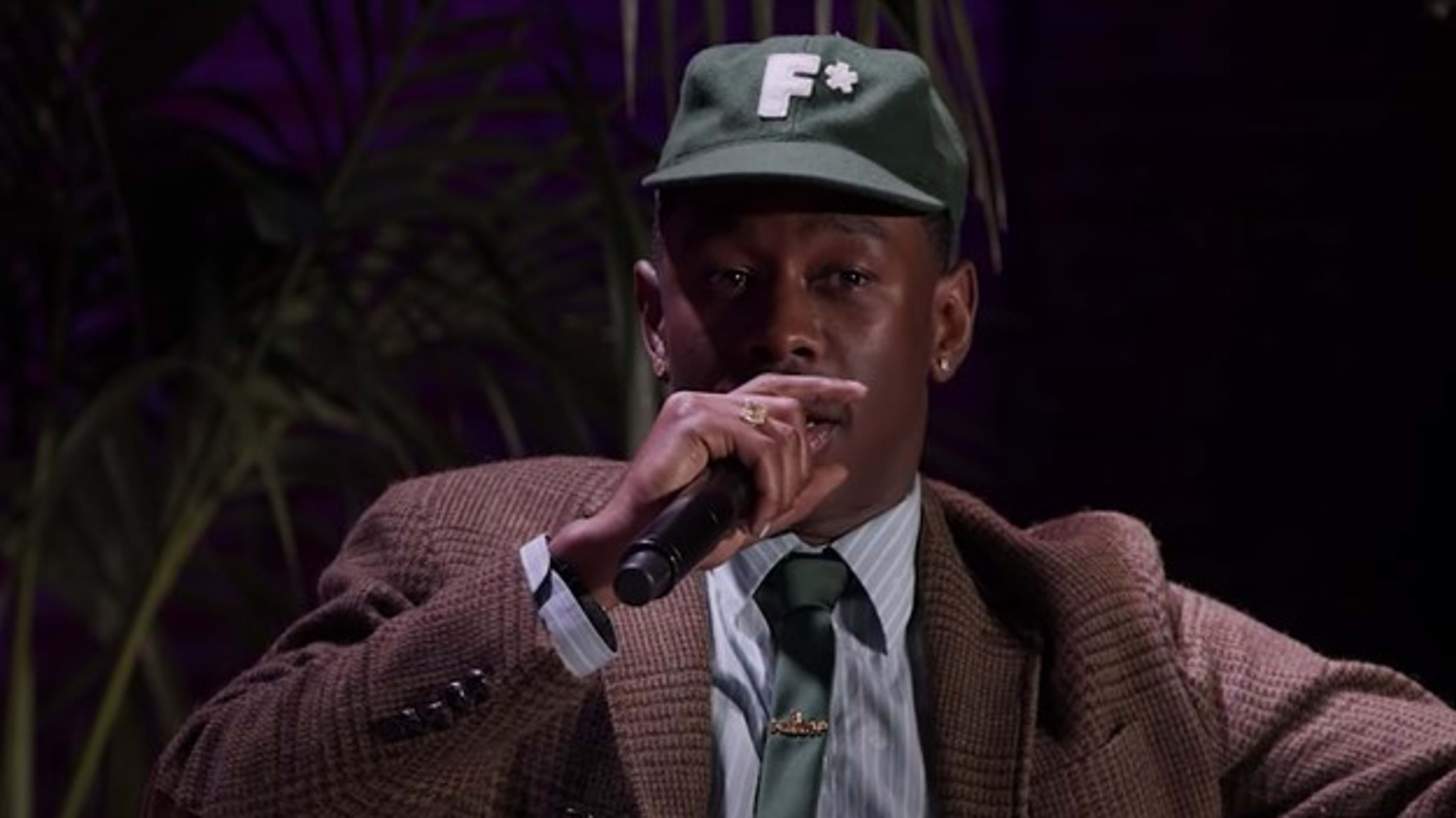 Tyler, the Creator is pictured speaking into a microphone