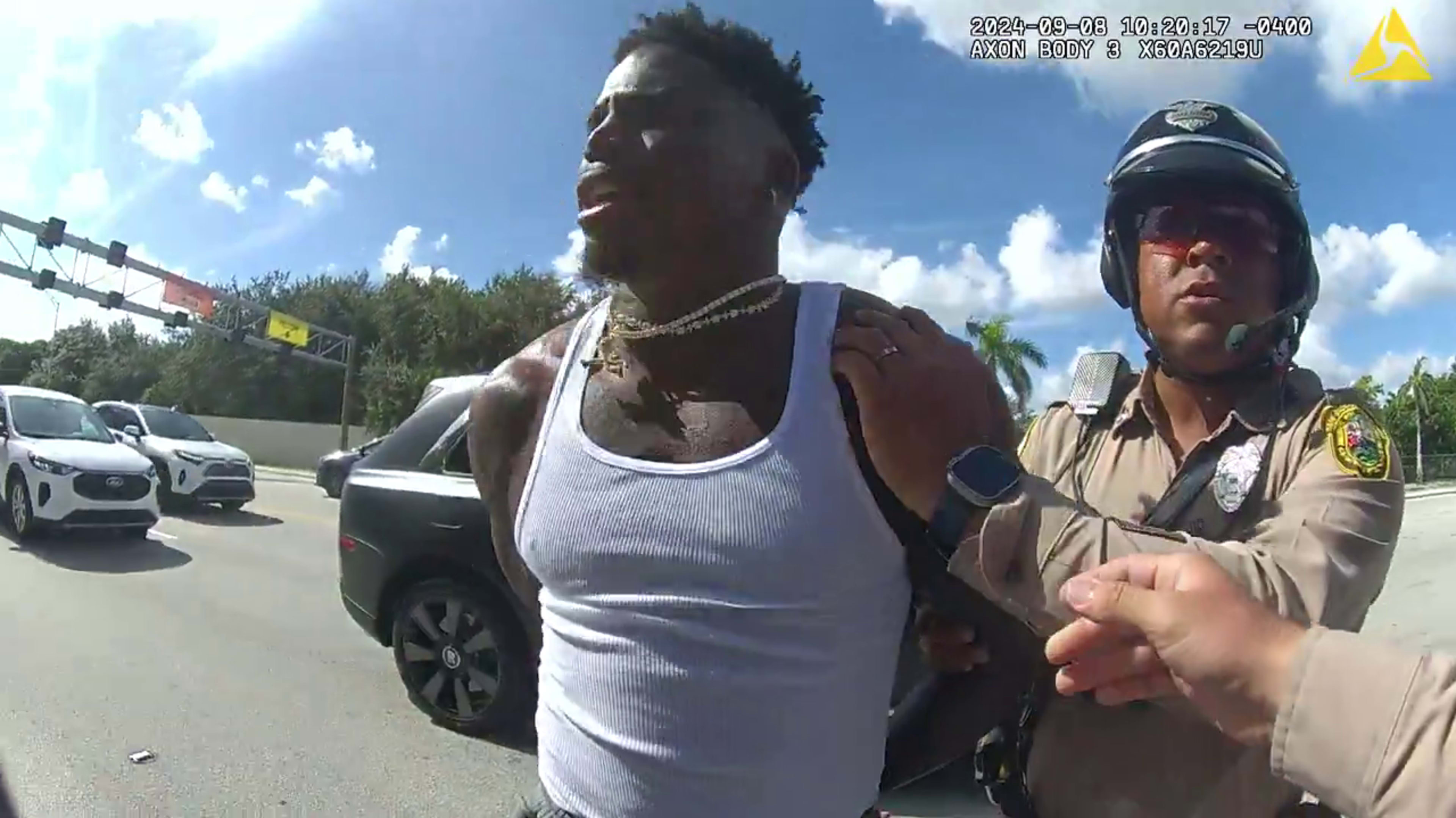 Tyreek Hill being detained by police.