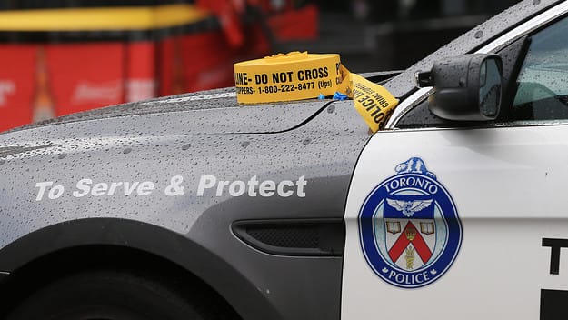 A Toronto Police Services car with caution tape sat on the hood.