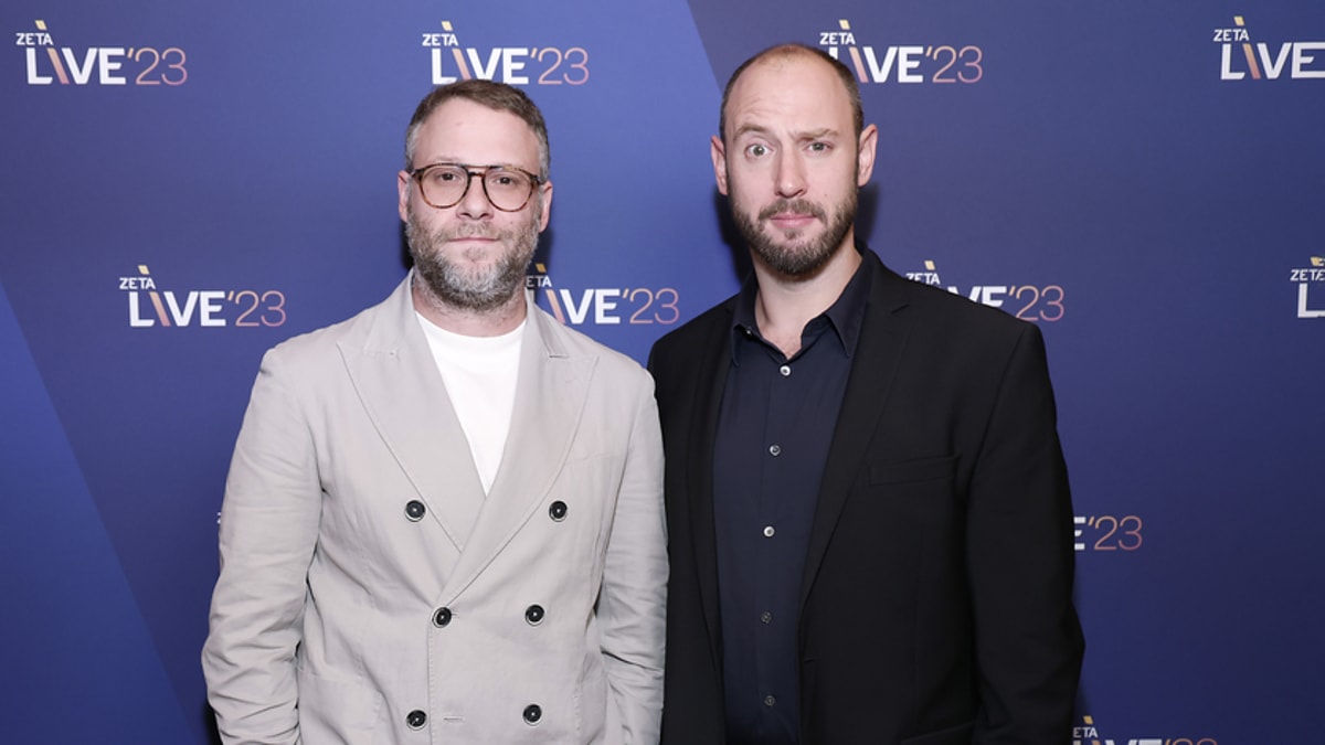 Seth Rogen in a light-colored double-breasted suit and Evan Goldberg in a dark suit at the ICJA LIVE23 event