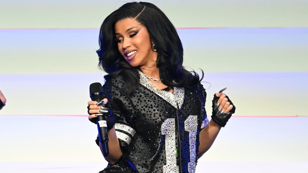 Cardi B performs on stage wearing a sequined jersey-style top with the number 11