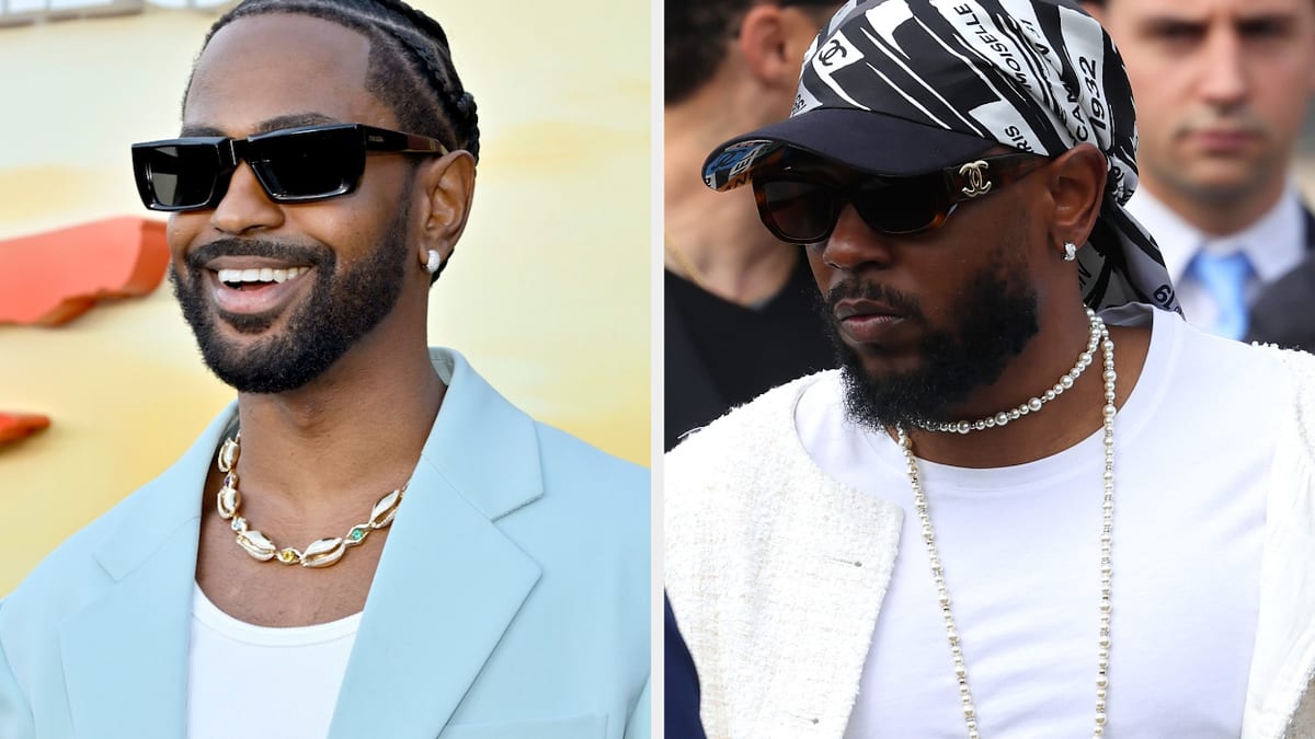Big Sean and Kendrick Lamar wearing stylish outfits and sunglasses at a public event. Big Sean is in a light-colored suit, and Kendrick Lamar wears a bandana and white jacket