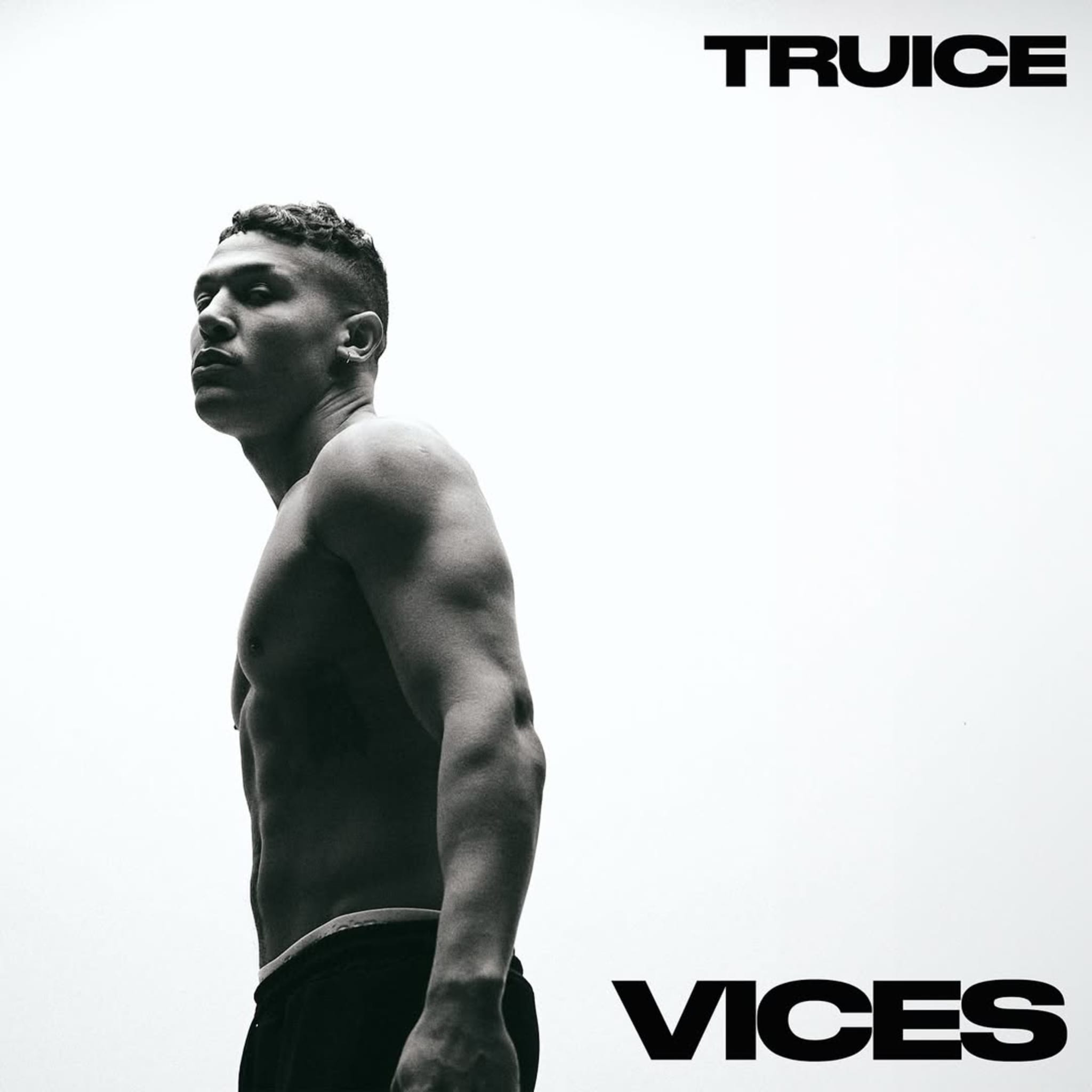 A black and white image of a shirtless man with short hair looking over his shoulder. The words "TRUICE" and "VICES" are in bold text.