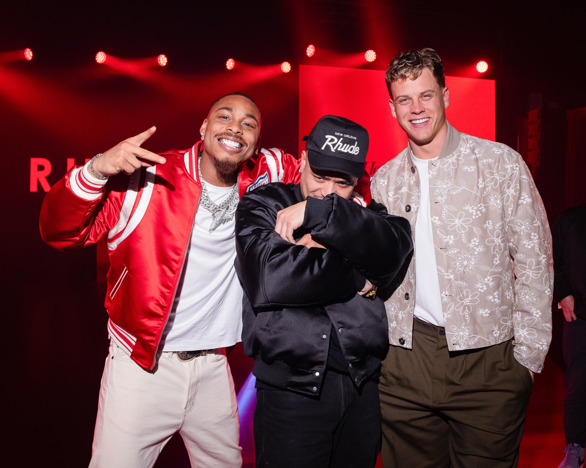Rhuigi, Justin Jefferson, and Joe Burrow posing together at Rhuigi’s “RHUDEBOY” Autumn/Winter 2025 preview at “House of Verizon” at Super Bowl LIX.