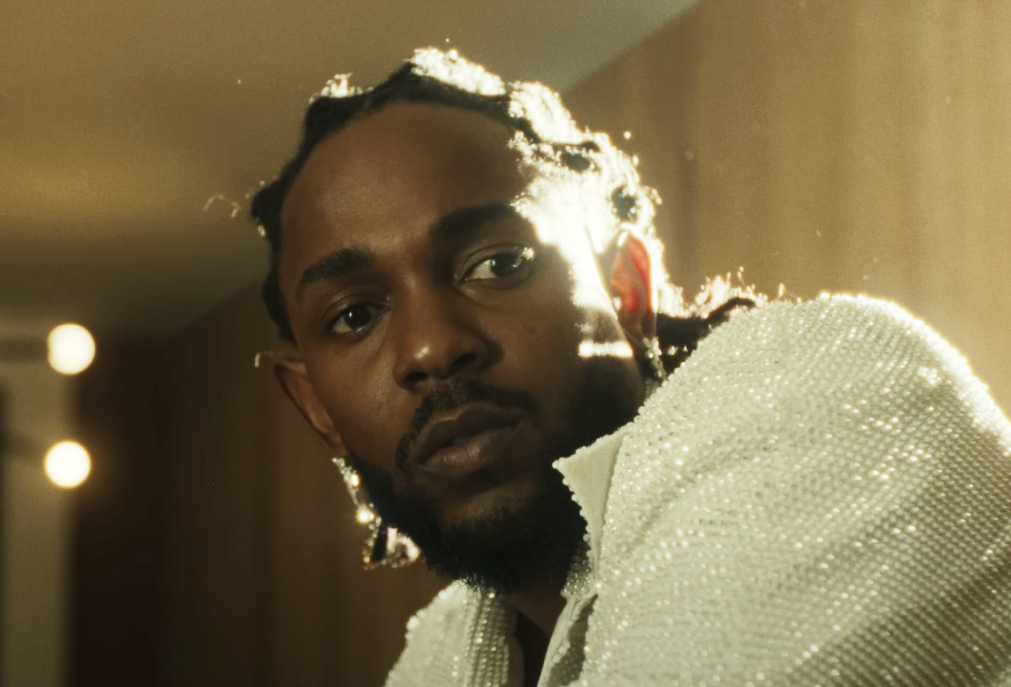 Man in a sequined jacket looking at the camera