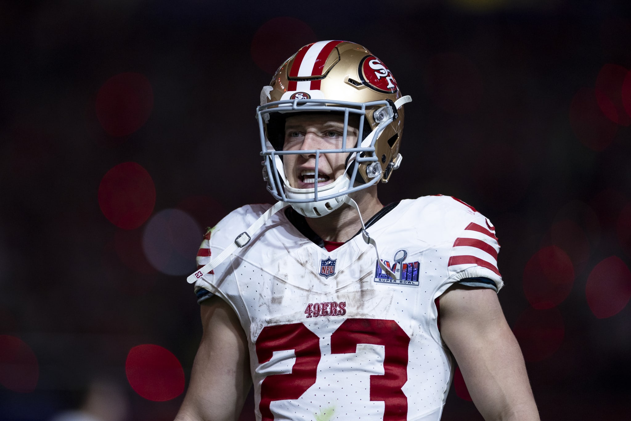 A football player wearing a San Francisco 49ers uniform and helmet, stands on the field during a game. The player's jersey number is 23