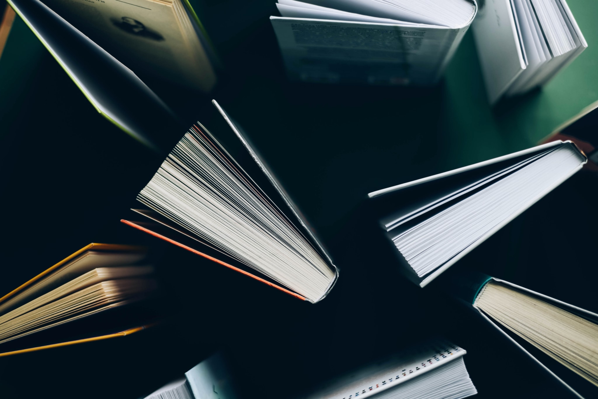 Top-down view of several open books arranged in a circular pattern