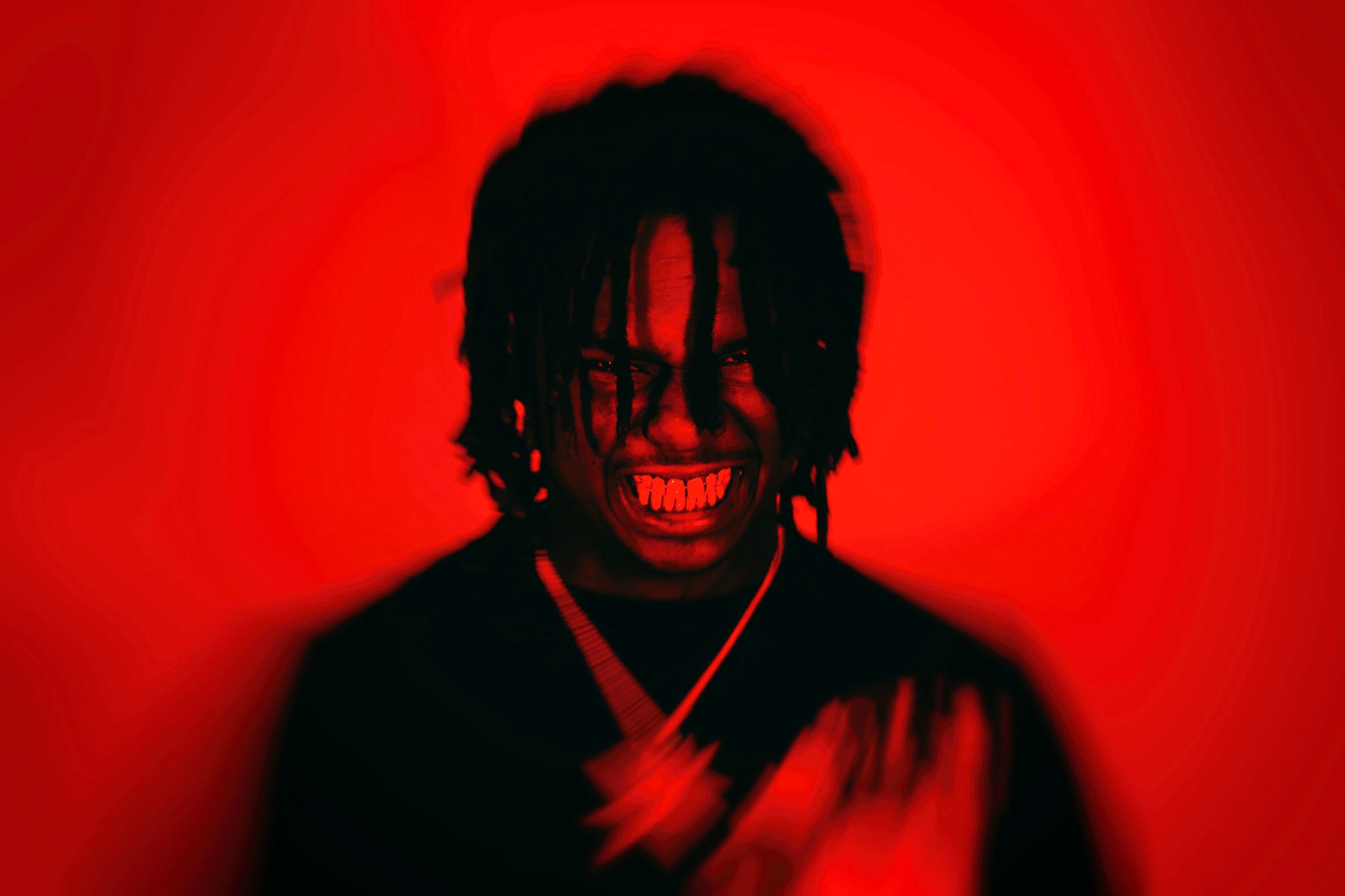 Duvy posing against red background, glaring teeth