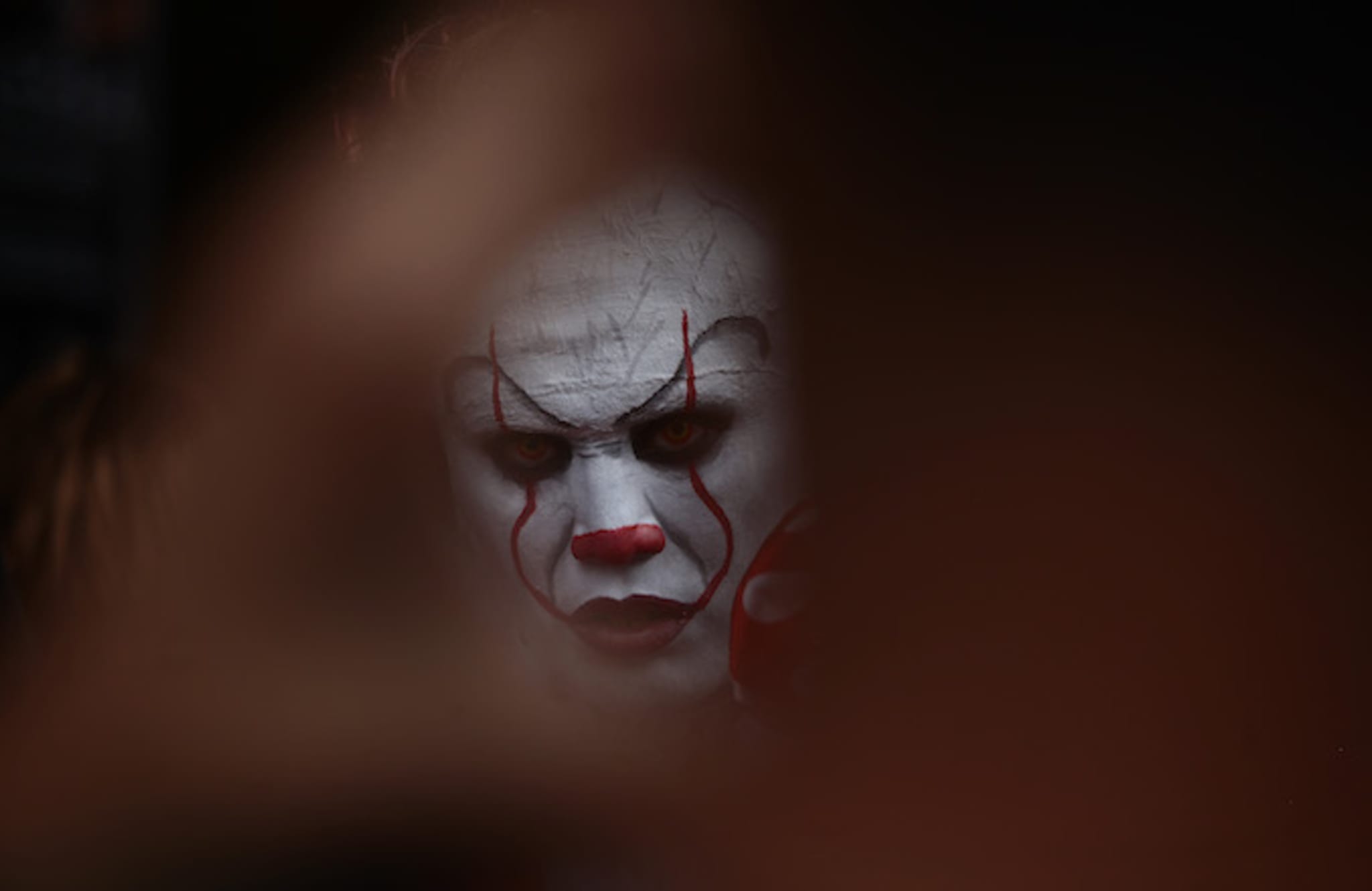 A man in the guise of IT the diabolical clown.