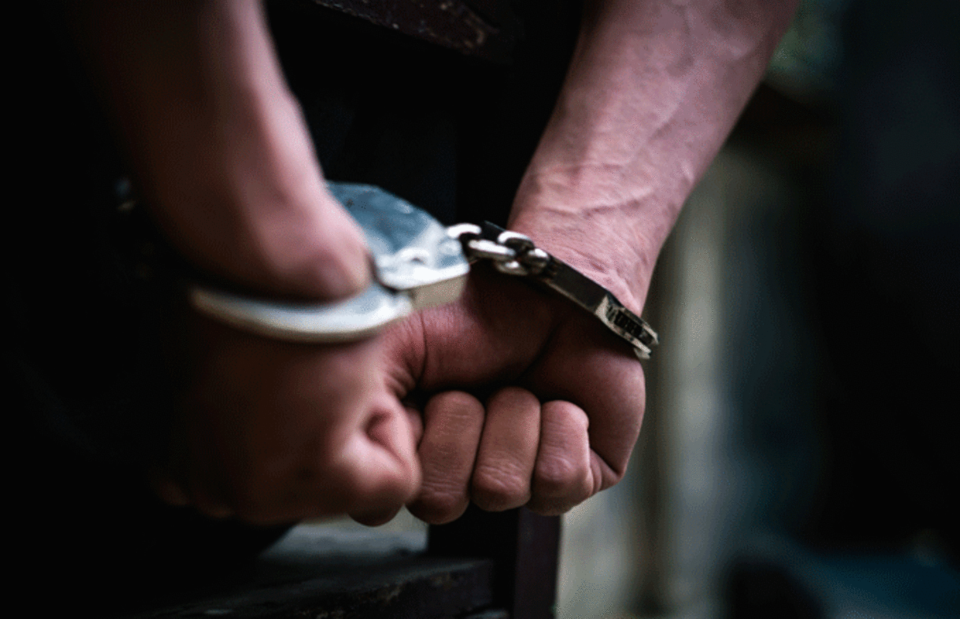 Stock image of handcuffed wrists.