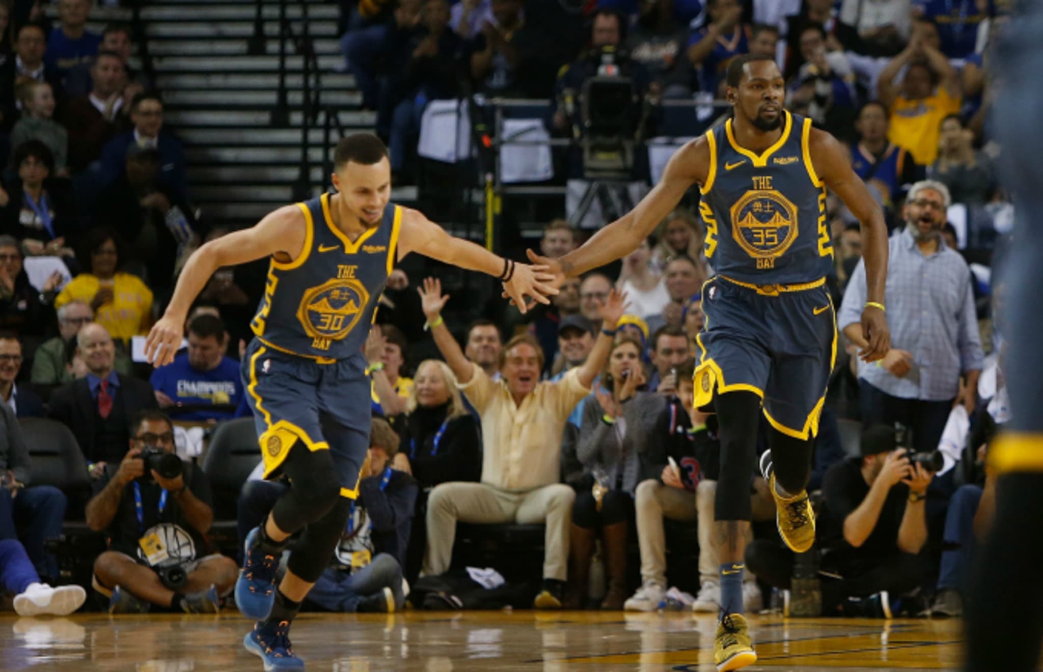 Stephen Curry #30 and Kevin Durant #35 of the Golden State Warriors celebrate a basket